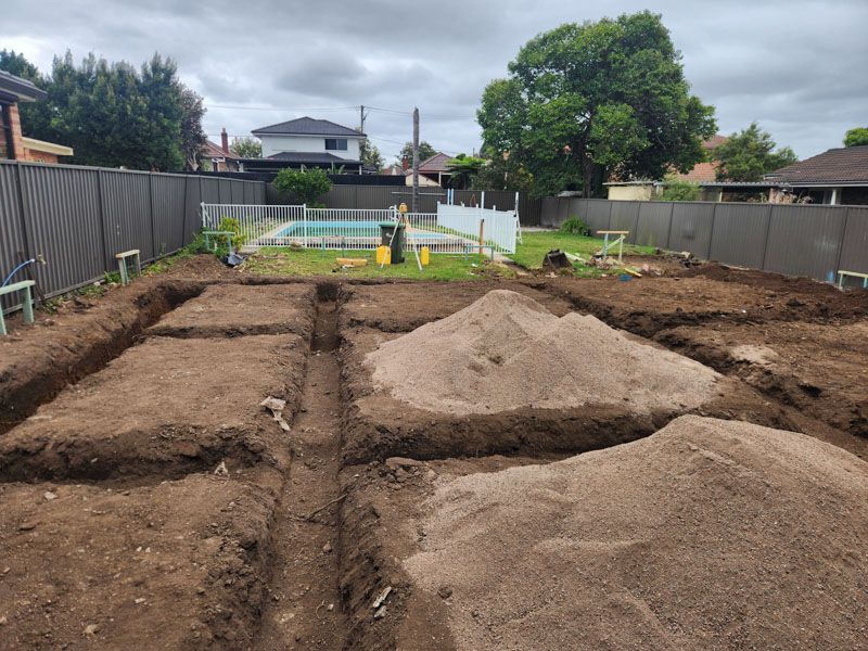 A pile of dirt is sitting in the middle of a backyard.