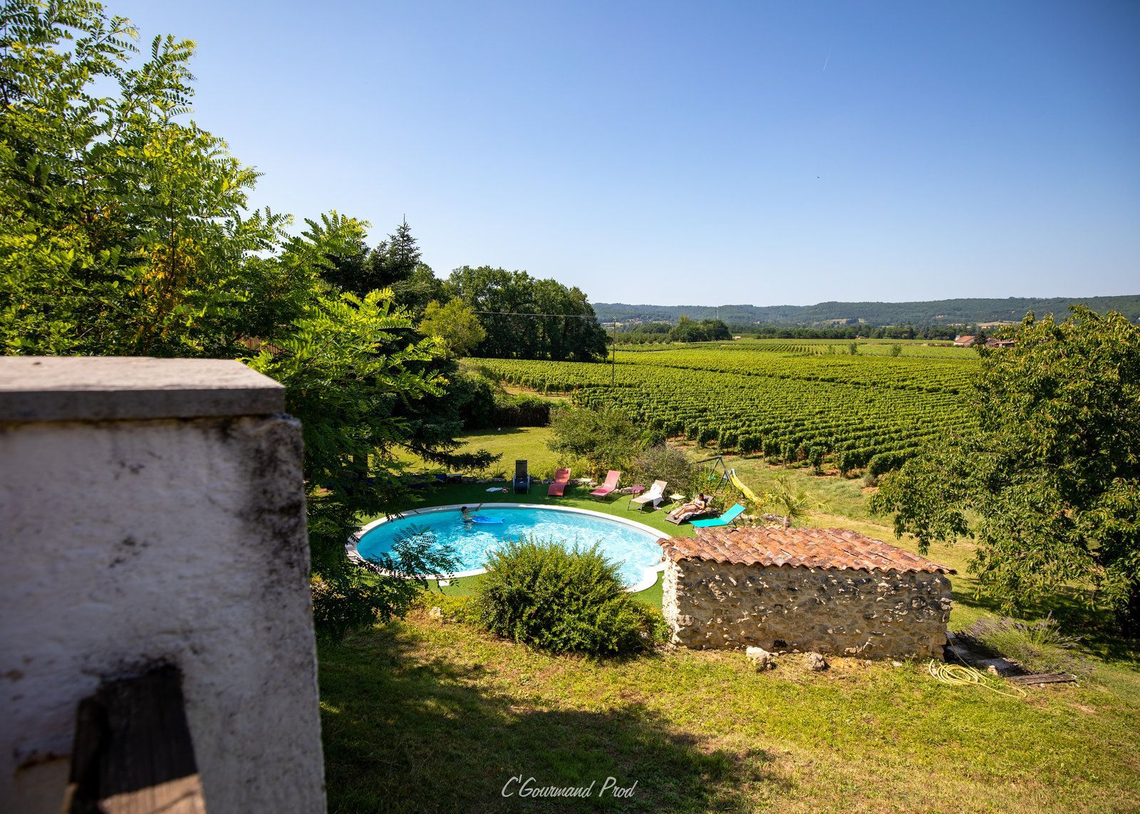 une grande piscine au milieu d'un champ verdoyant