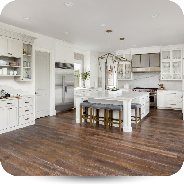 Bright modern kitchen with white cabinets, stainless fridge, island, and wooden floors