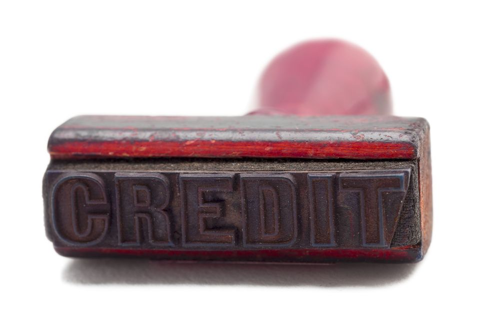 An image of an ink stamp lying horizontally and exposing the bottom of the stamp that says 'Credit'
