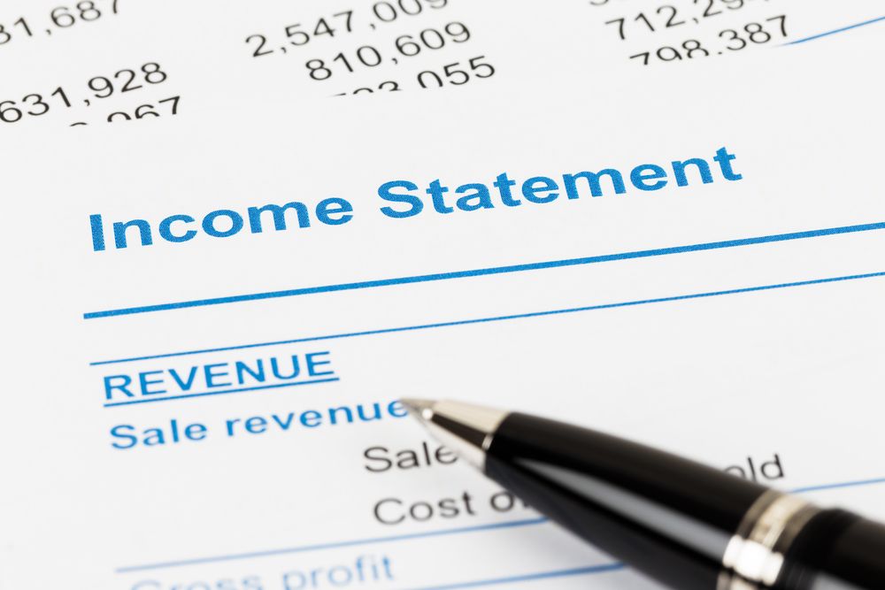 An image of a pen resting on an income statement report.