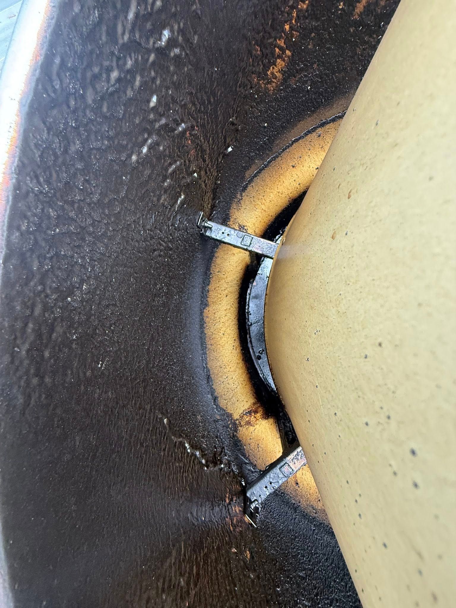 Close-up of a metal ring and two silver clips against a black and yellow surface
