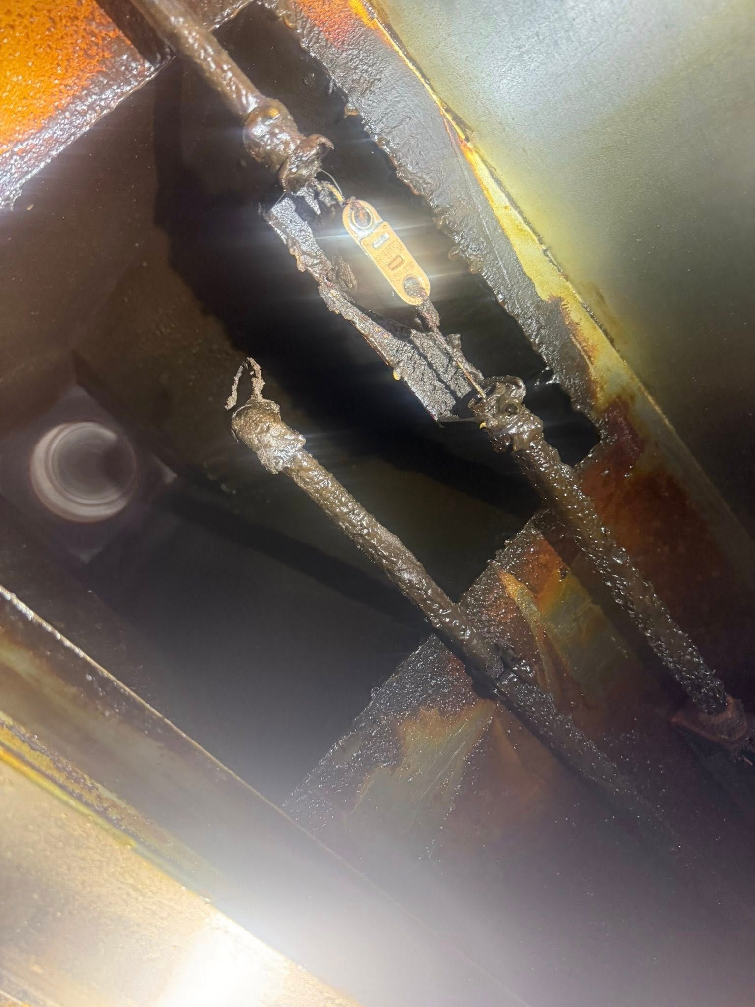 Close-up of a dimly lit metallic mechanism with braided cables and a round opening.