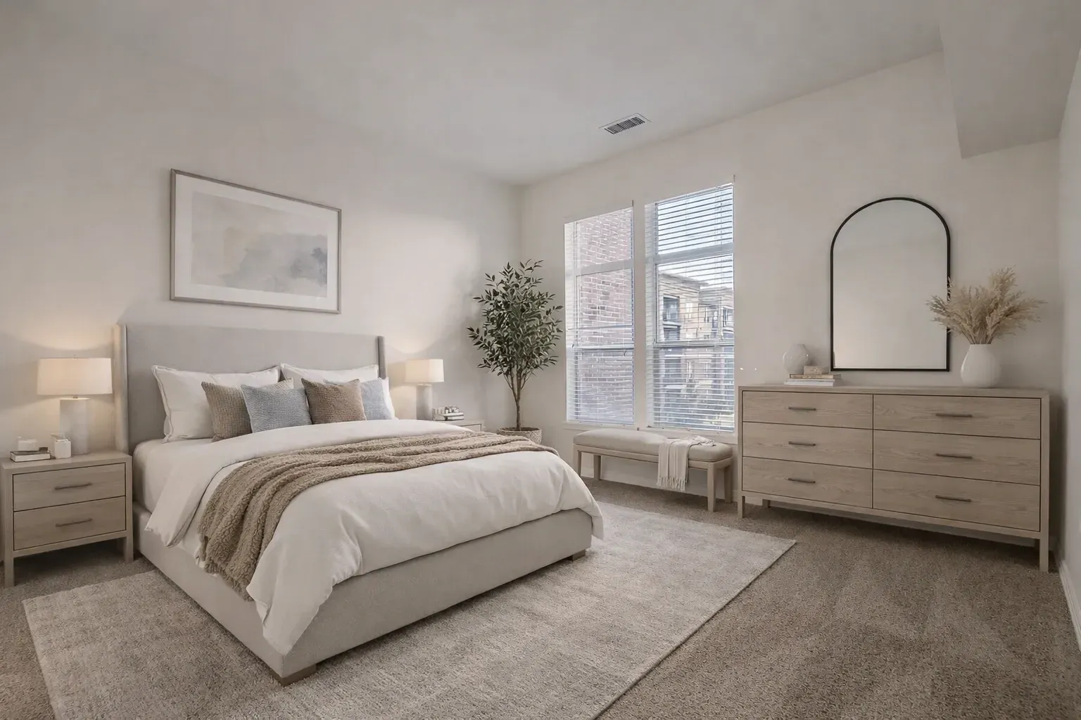 A beautifully staged bedroom with a king-sized bed, nightstands, a dresser, and a large window.