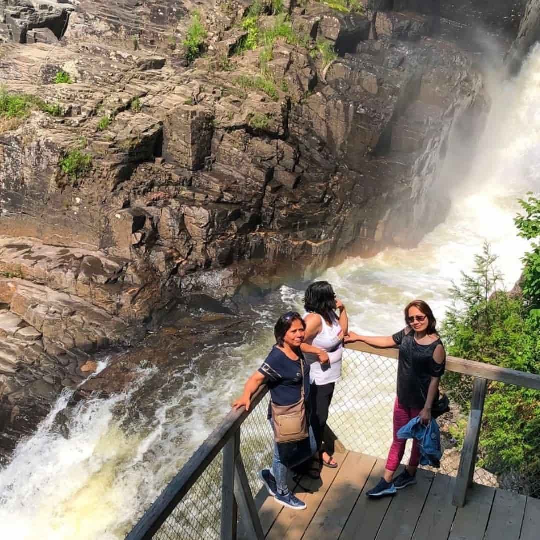 Active travellers enjoying the scenic Canyon Sainte-Anne waterfall and lookout near Québec City