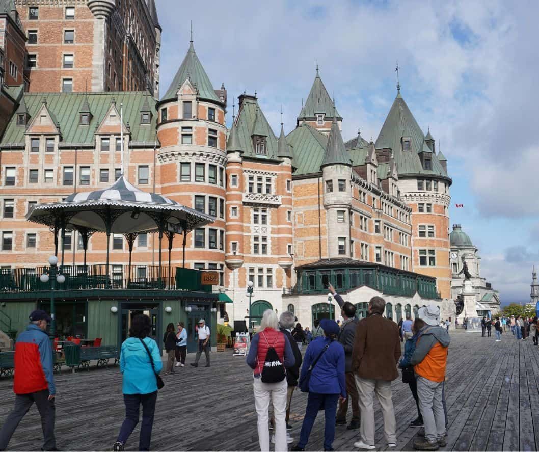 Guests walking along Dufferin Terrace beside Fairmont Le Château Frontenac in Québec City.