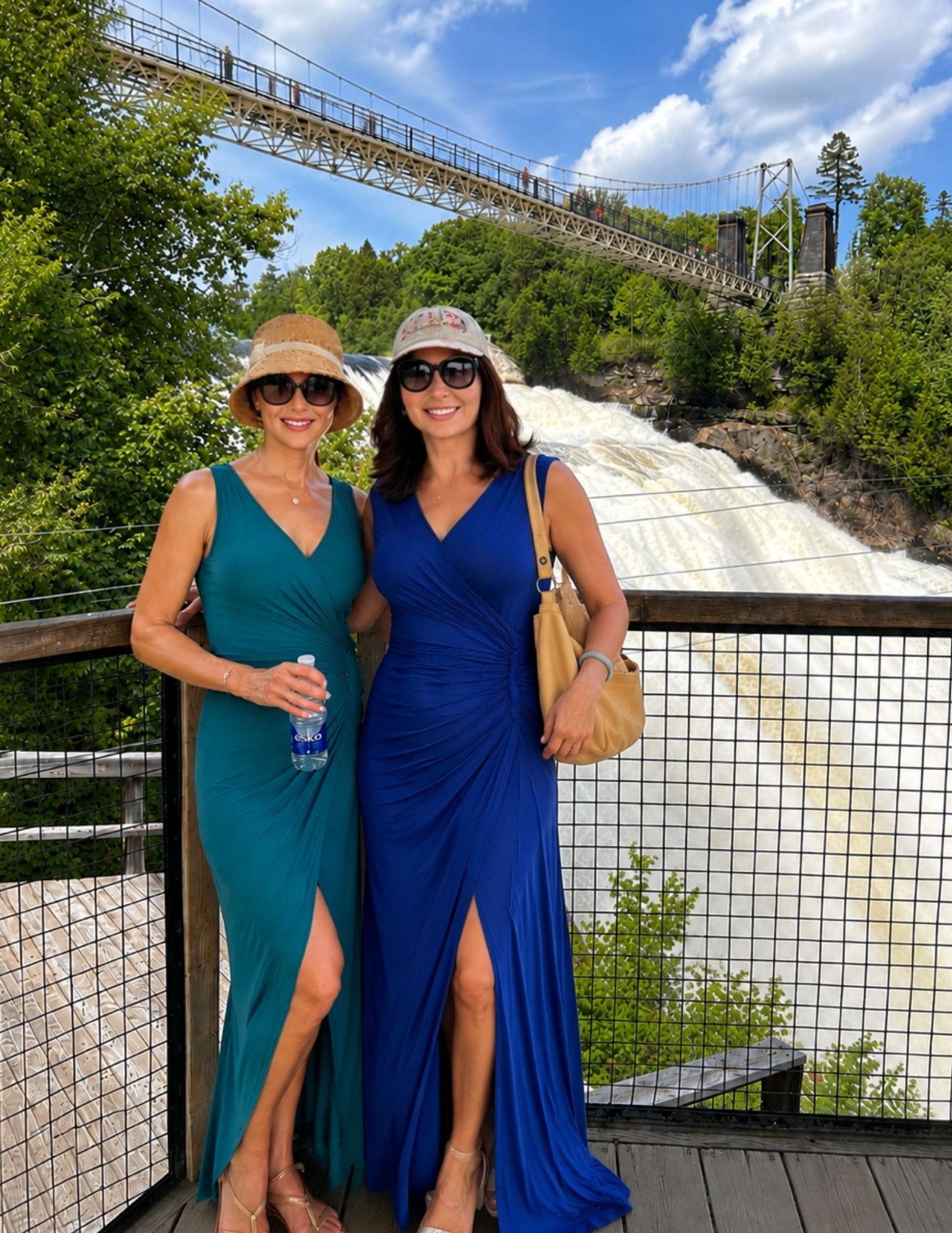 Travelers posing in front of Montmorency Falls and suspension bridge near Québec City during a CosmoVista Tours guided tour.