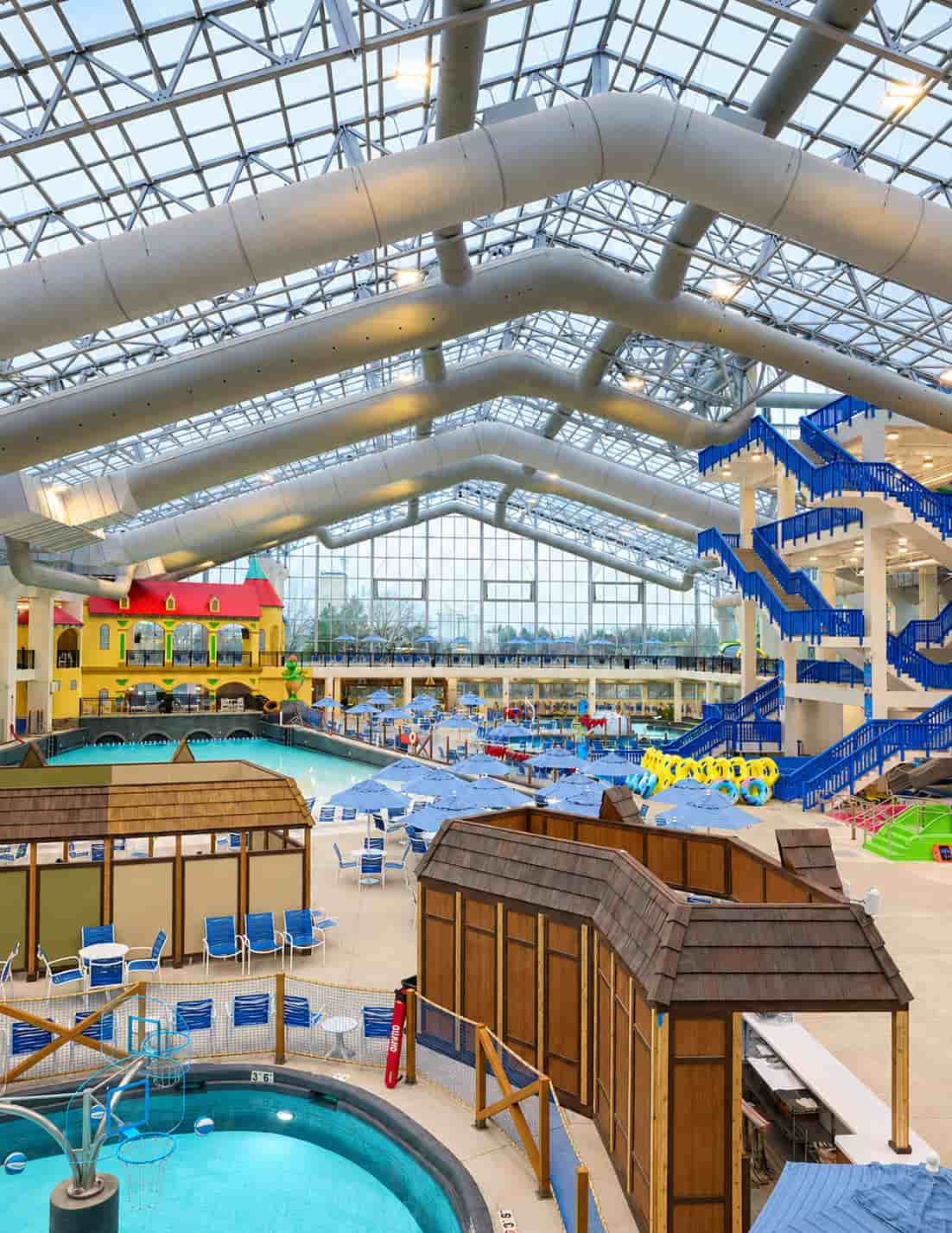 Indoor water park at the Bavarian Inn Lodge in Frankenmuth, Michigan, featuring pools, waterslides and seating beneath a glass roof.