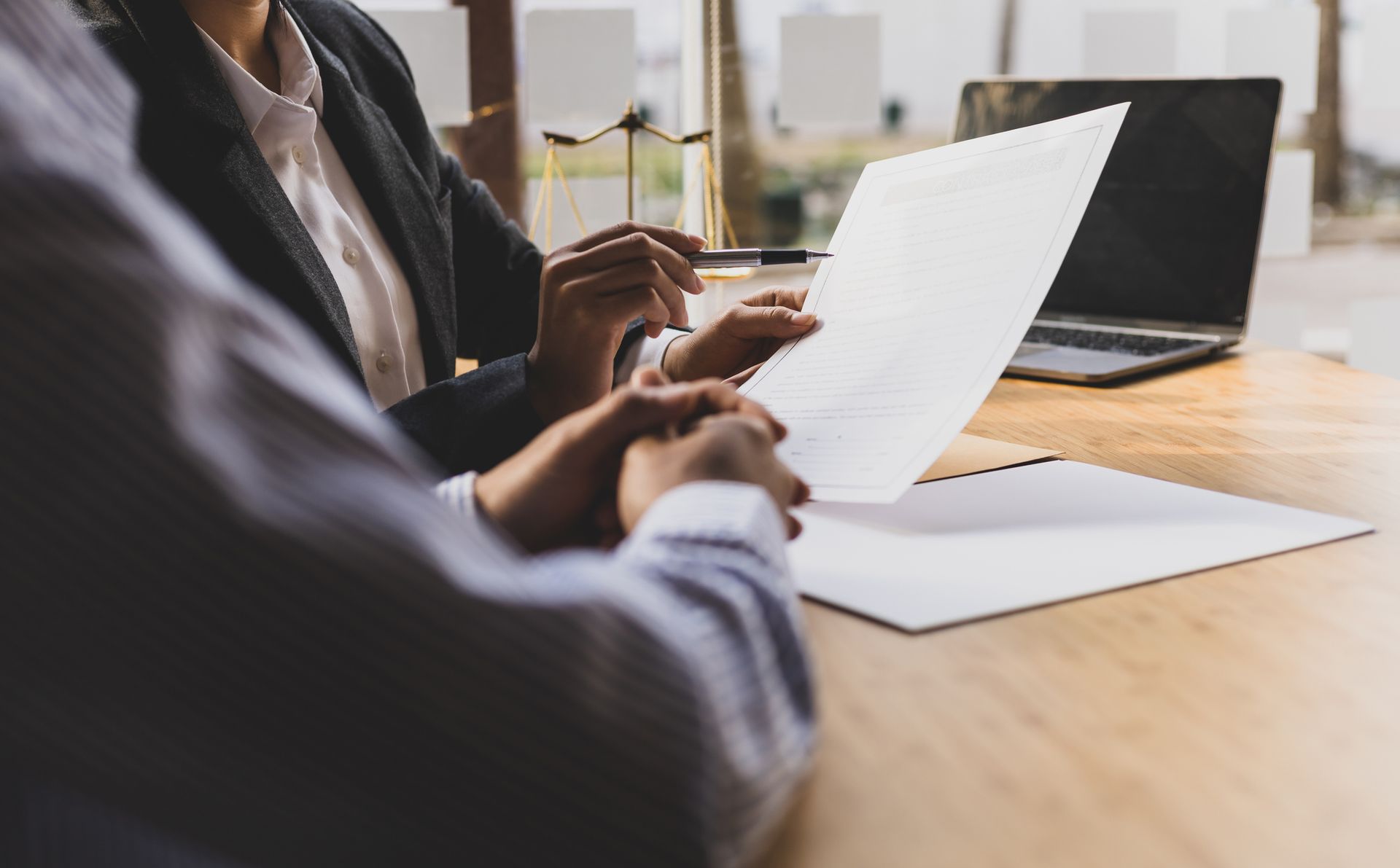 An attorney and client sitting at a desk looking at a legal document