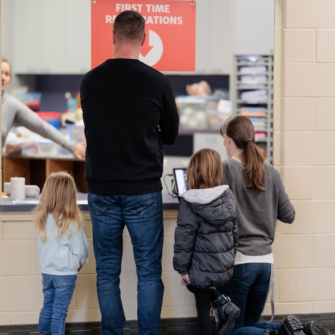 A group of people standing in front of a sign that says first time registrations