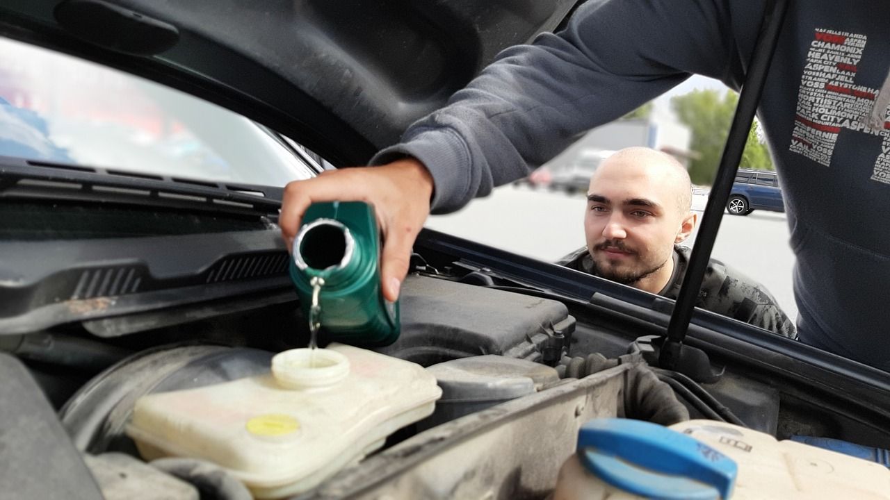 Pouring engine oil into vehicle | Larsen Automotive Inc