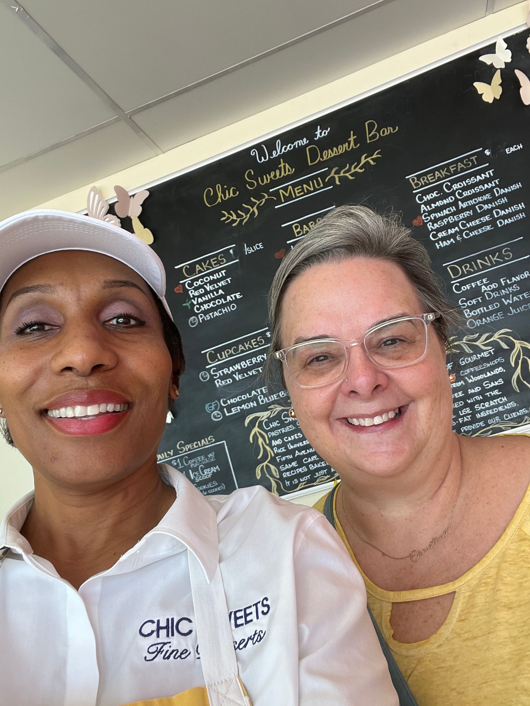 Bakery Owner and Guest standing in front of menu board