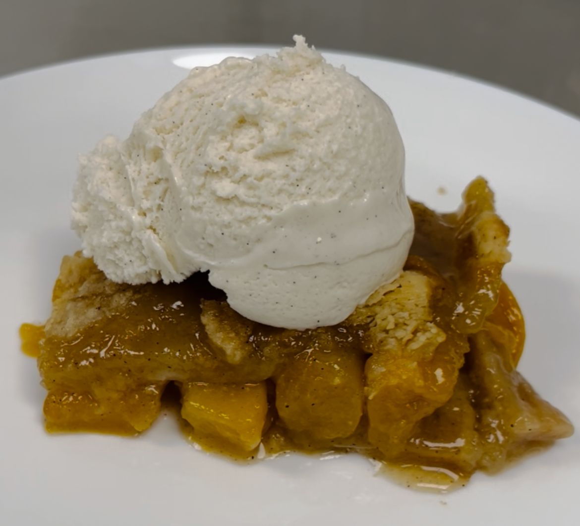Peach Cobbler with a scoop of vanilla ice cream