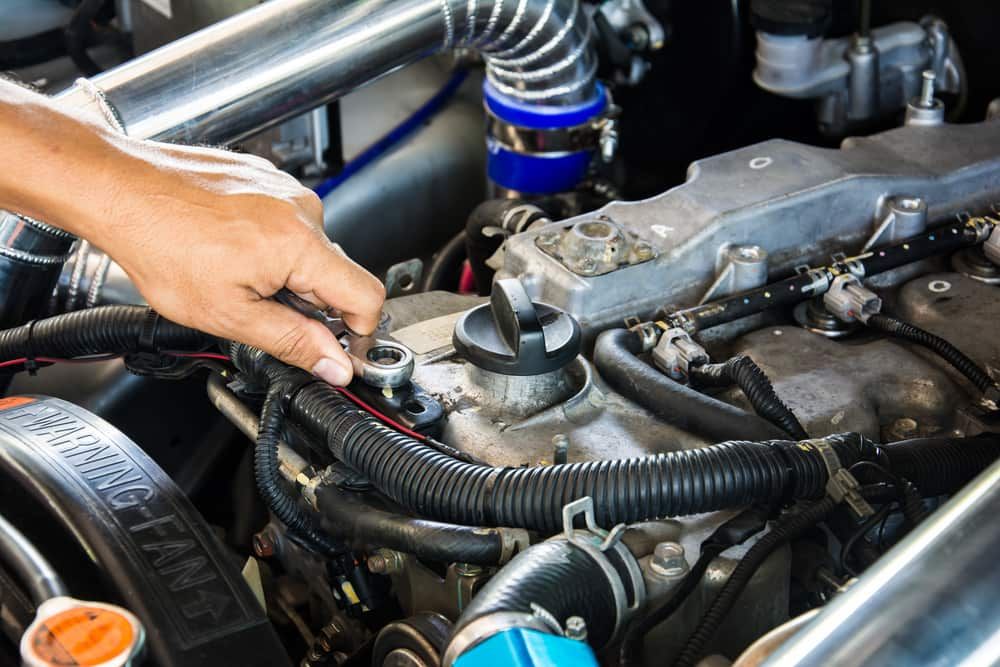 A Person Is Working On A Car Engine With A Screwdriver — Automotive Repair Centre In Garbutt, QLD