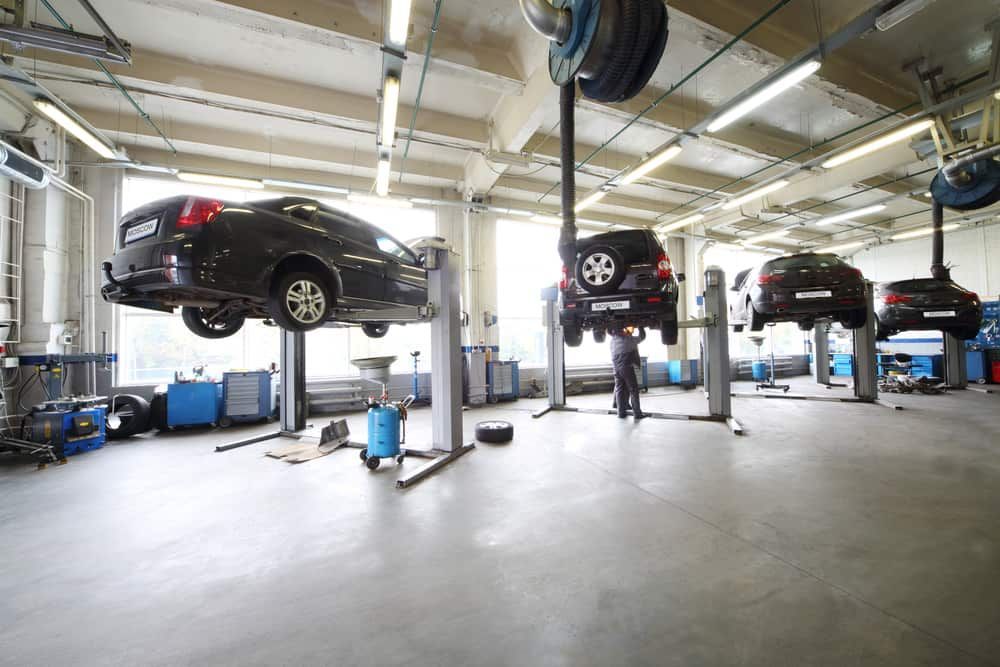 A Row Of Cars Are Sitting On Lifts In A Garage — Automotive Repair Centre In Garbutt, QLD