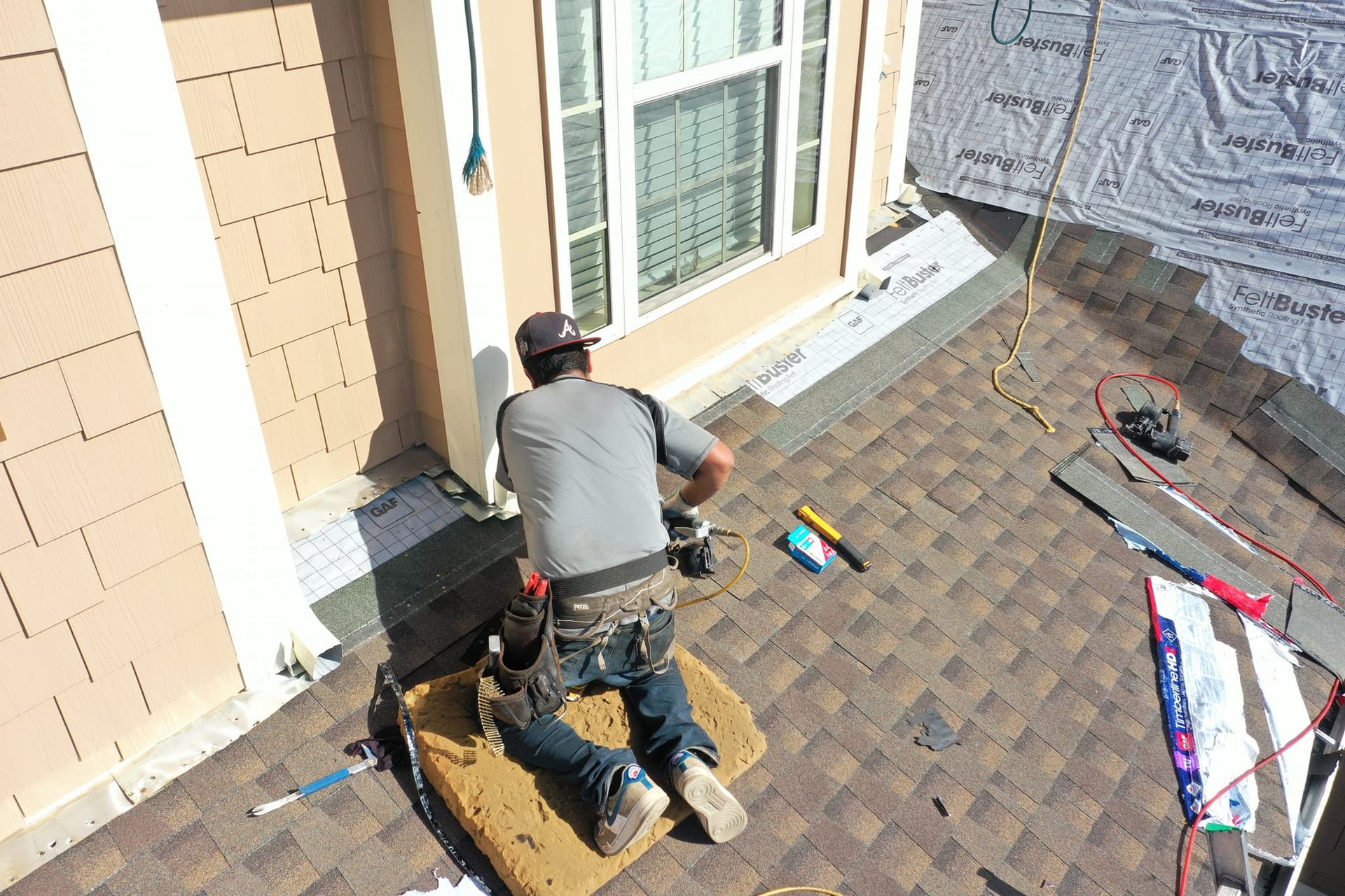 A man is working on the roof of a house