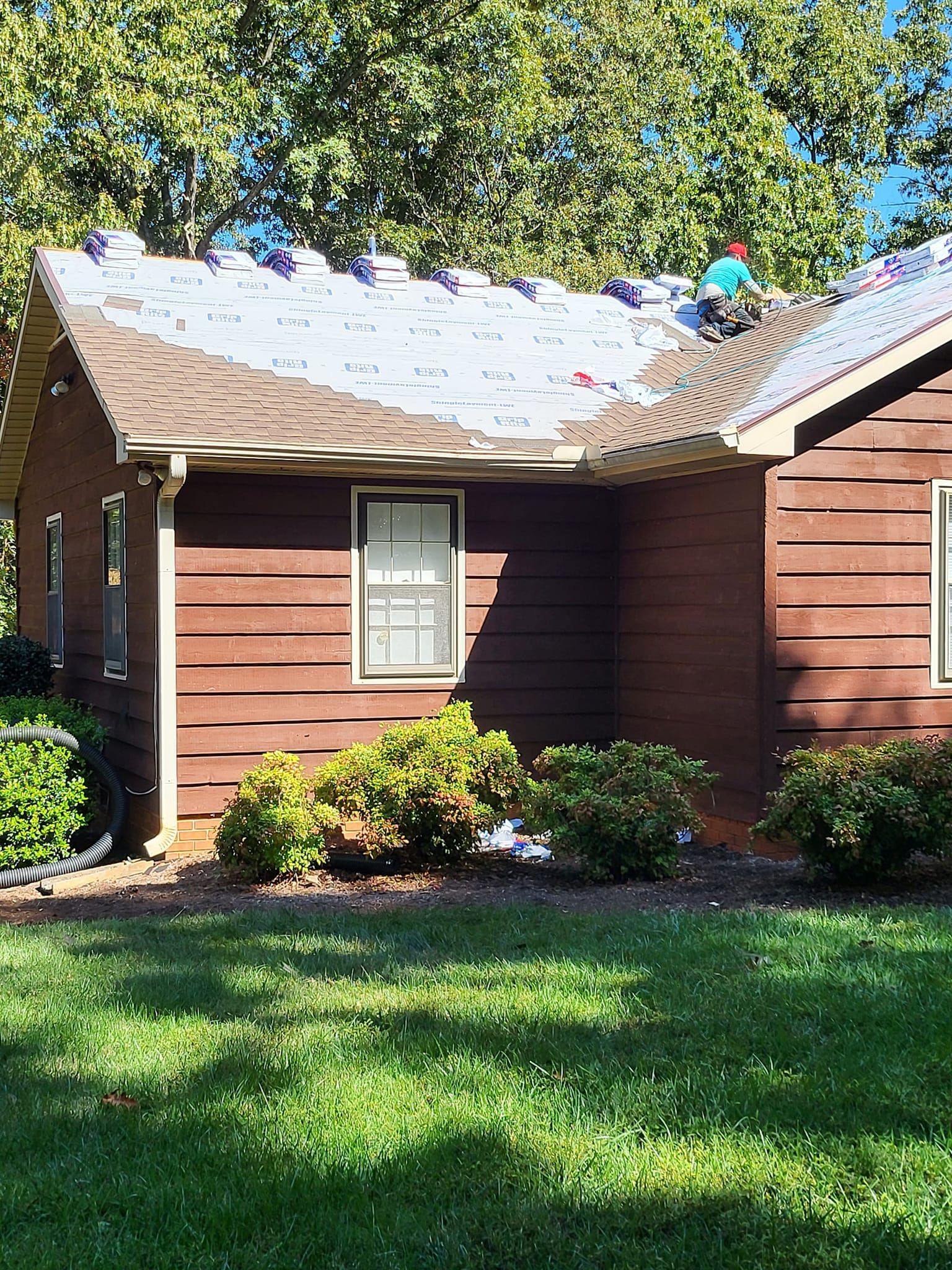 A man is working on the roof of a house