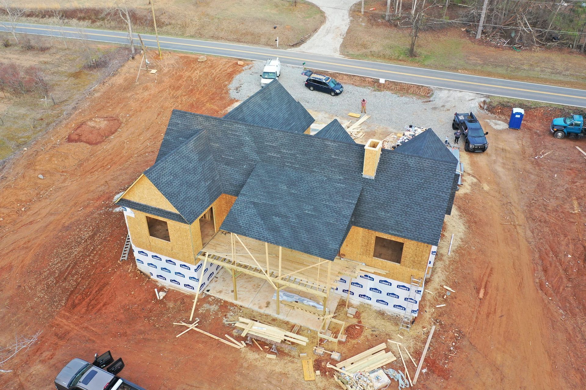 An aerial view of a house under construction with a black roof
