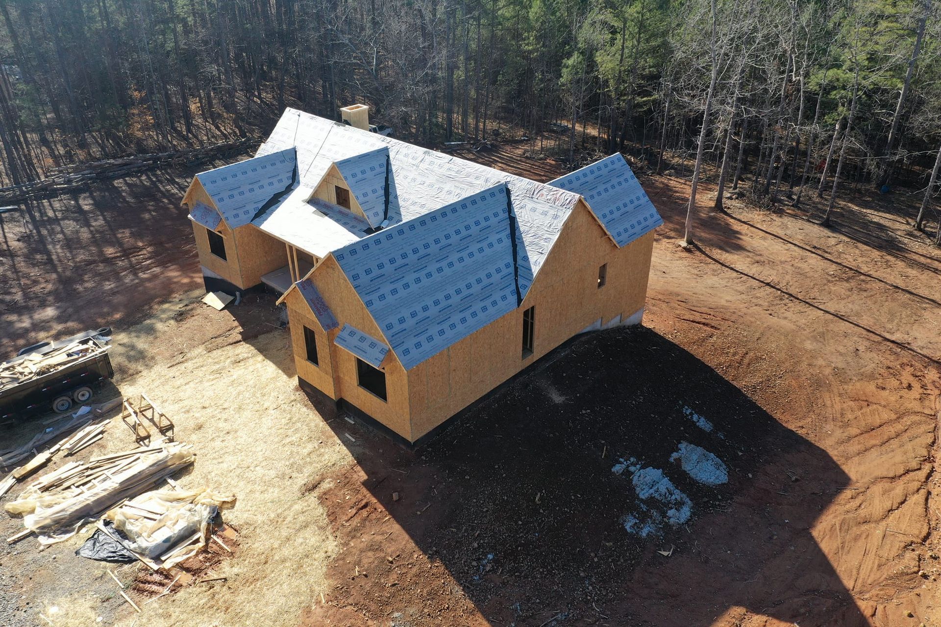 An aerial view of a house under construction in the woods
