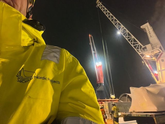 A man wearing a yellow jacket that says nordic projects
