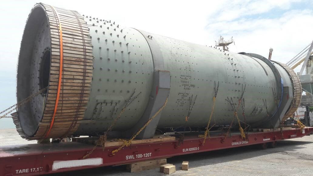 A large pipe is sitting on top of a train.