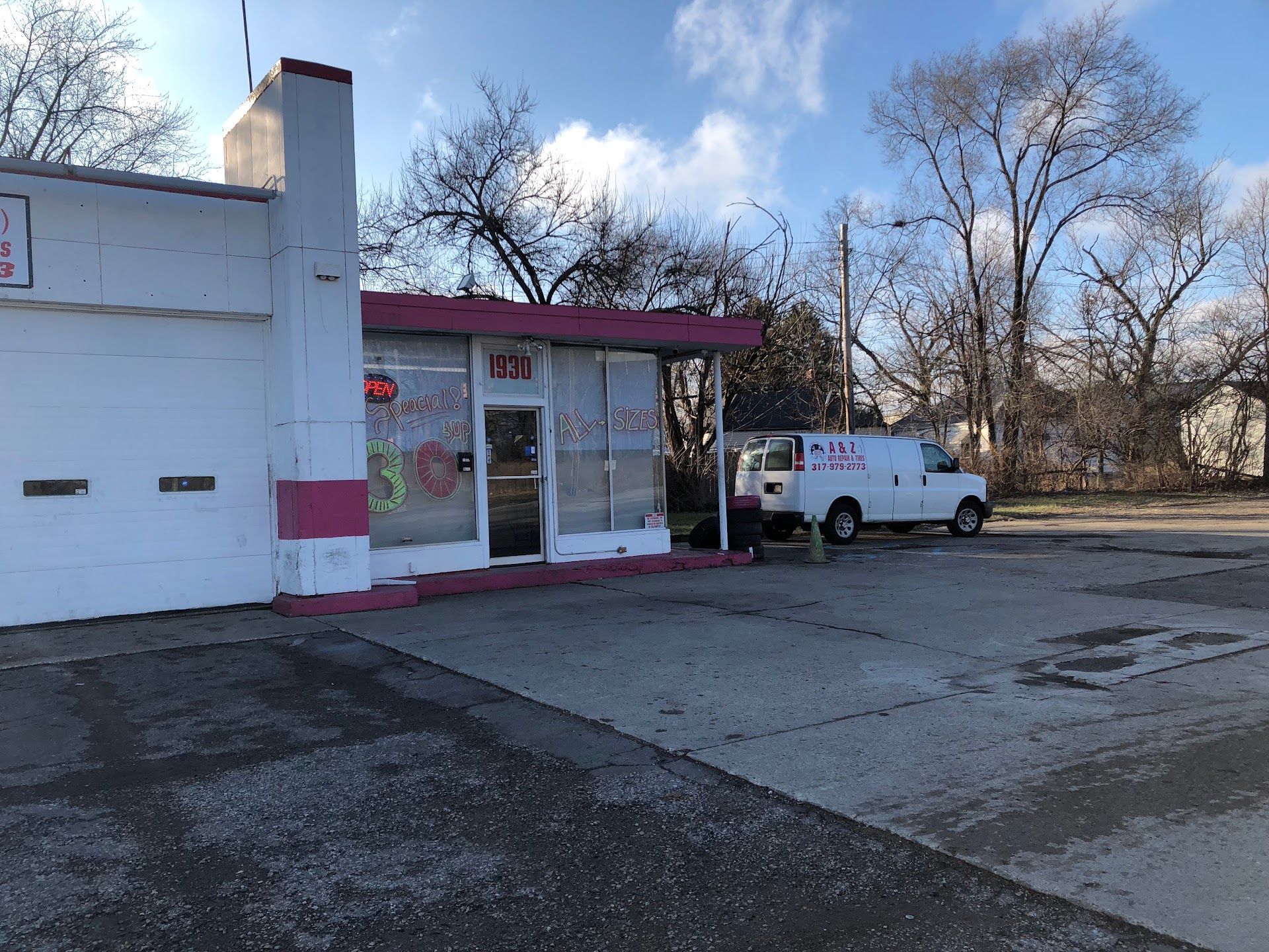 Small roadside shop with a white van parked outside under a partly cloudy sky. | A & Z Auto Repair