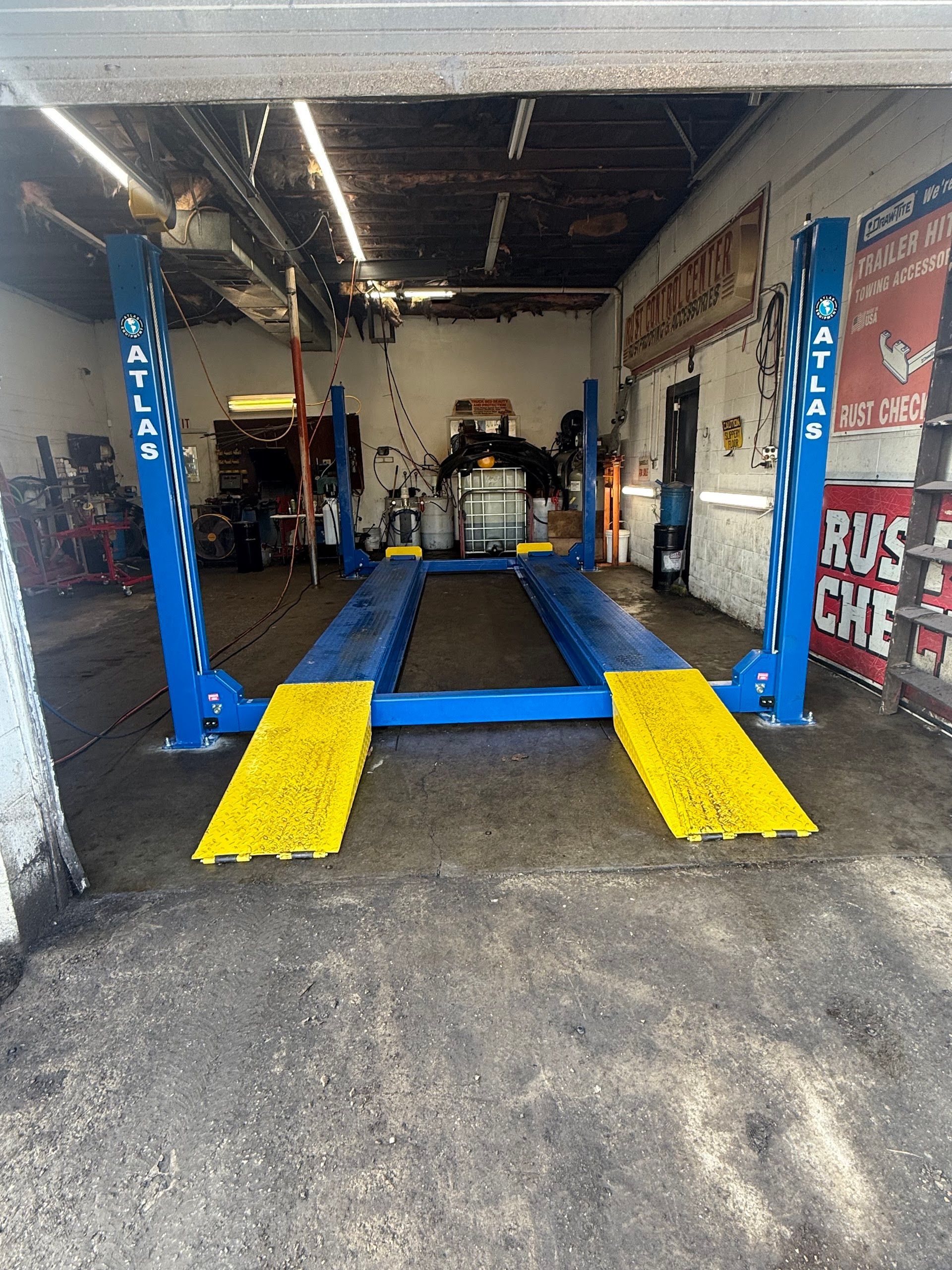 Auto repair shop with blue car lift, yellow ramps, and vehicle service bay. | A & Z Auto Repair