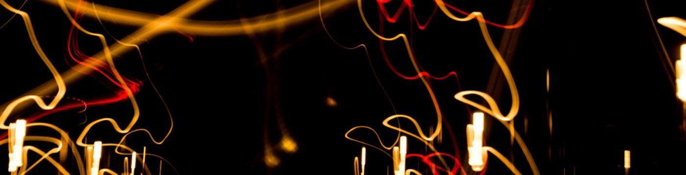A bunch of lights are glowing in the dark on a black background.