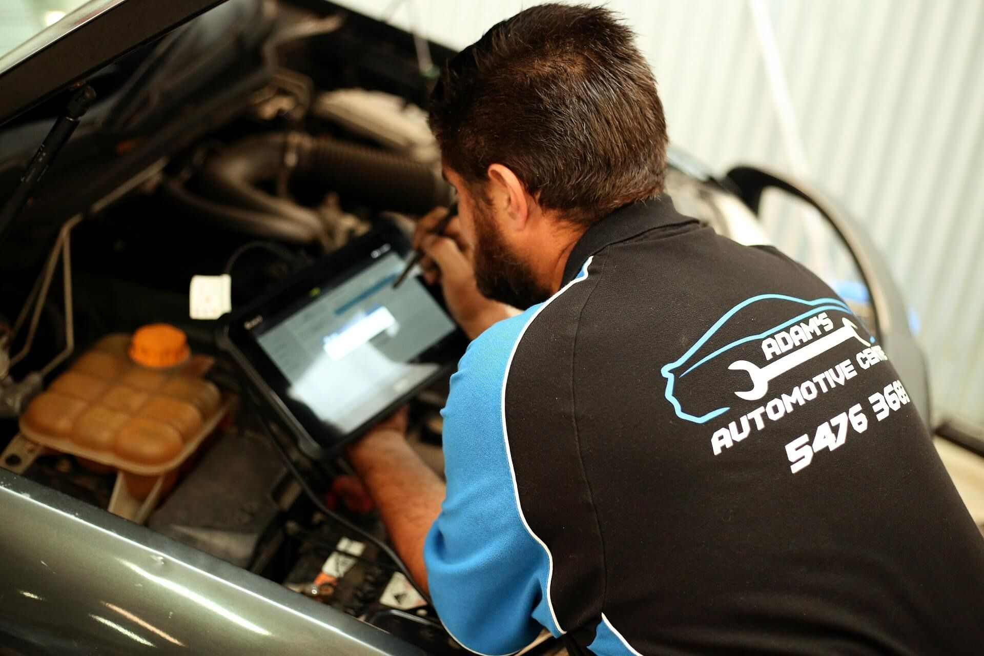 Mechanic Using a Tablet to Diagnose a Car Engine — Adam's Automotive Centre in Nambour, QLD