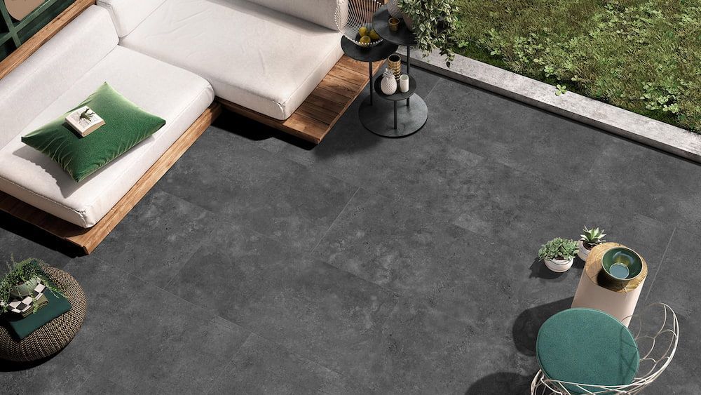 An Aerial View of a Patio With a Couch, Table and Chairs — Tileflair in Mitchell, ACT