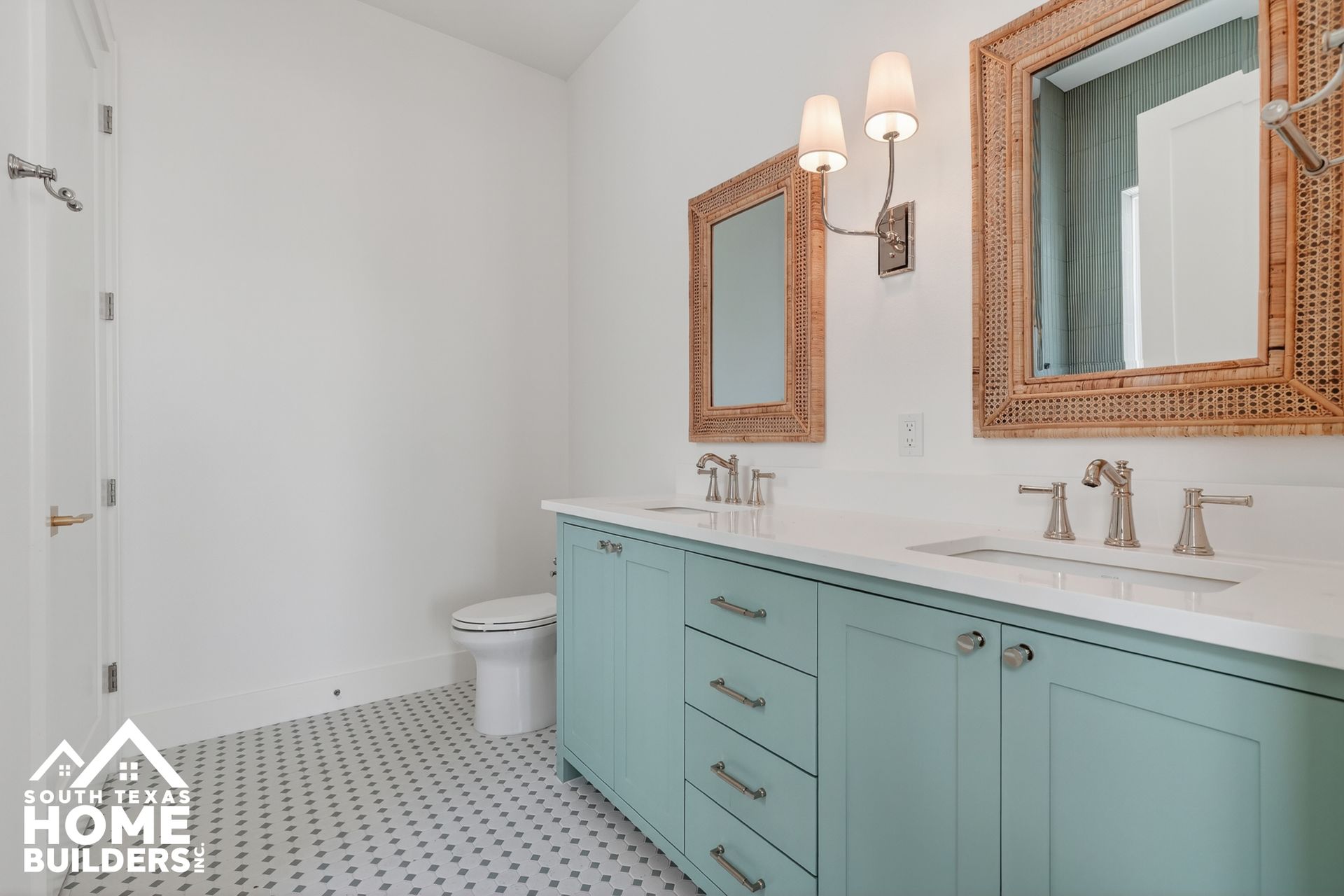 Bright bathroom with mint vanity, twin mirrors, and patterned floor tiles