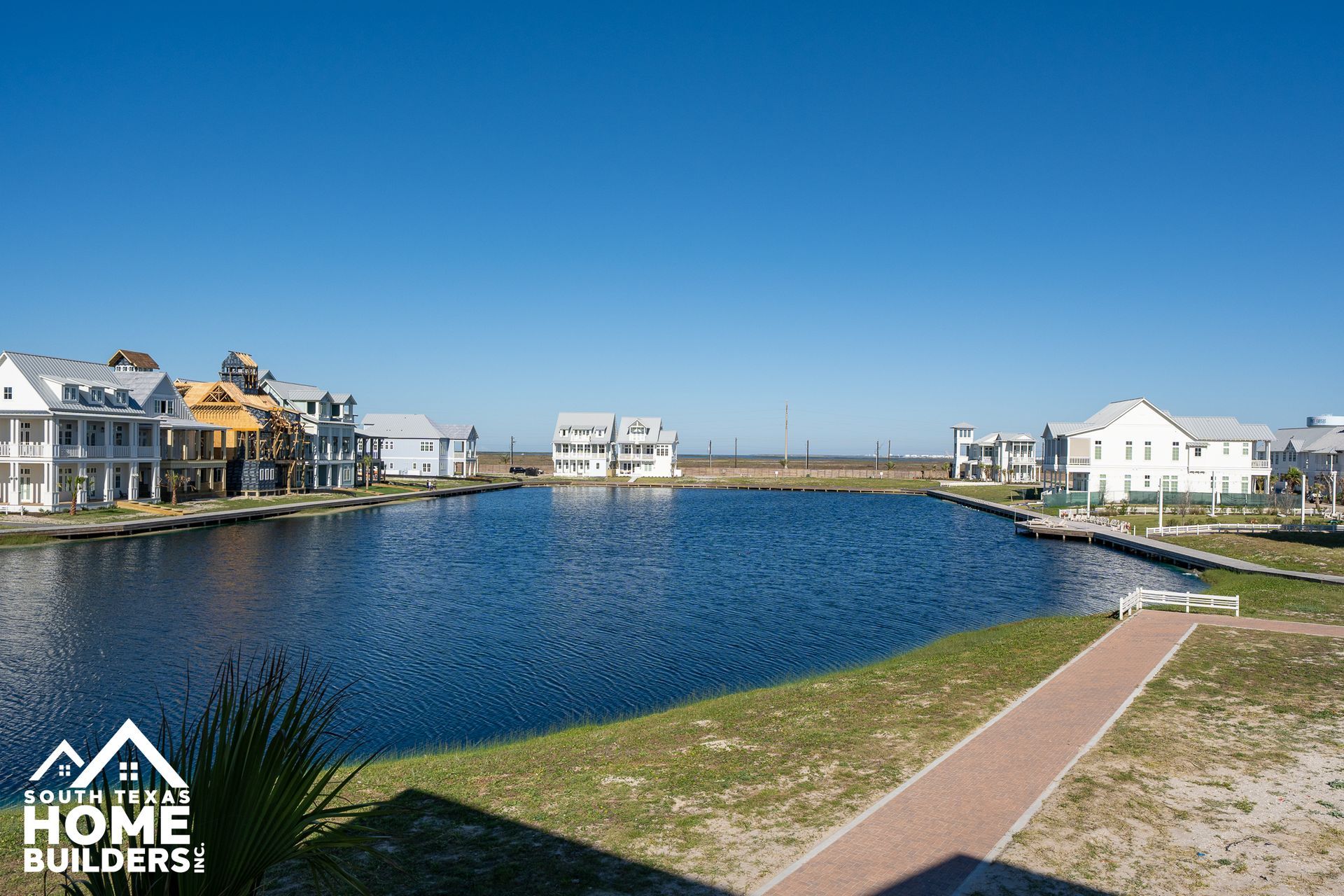 Waterfront homes around a calm blue lagoon under a clear sky