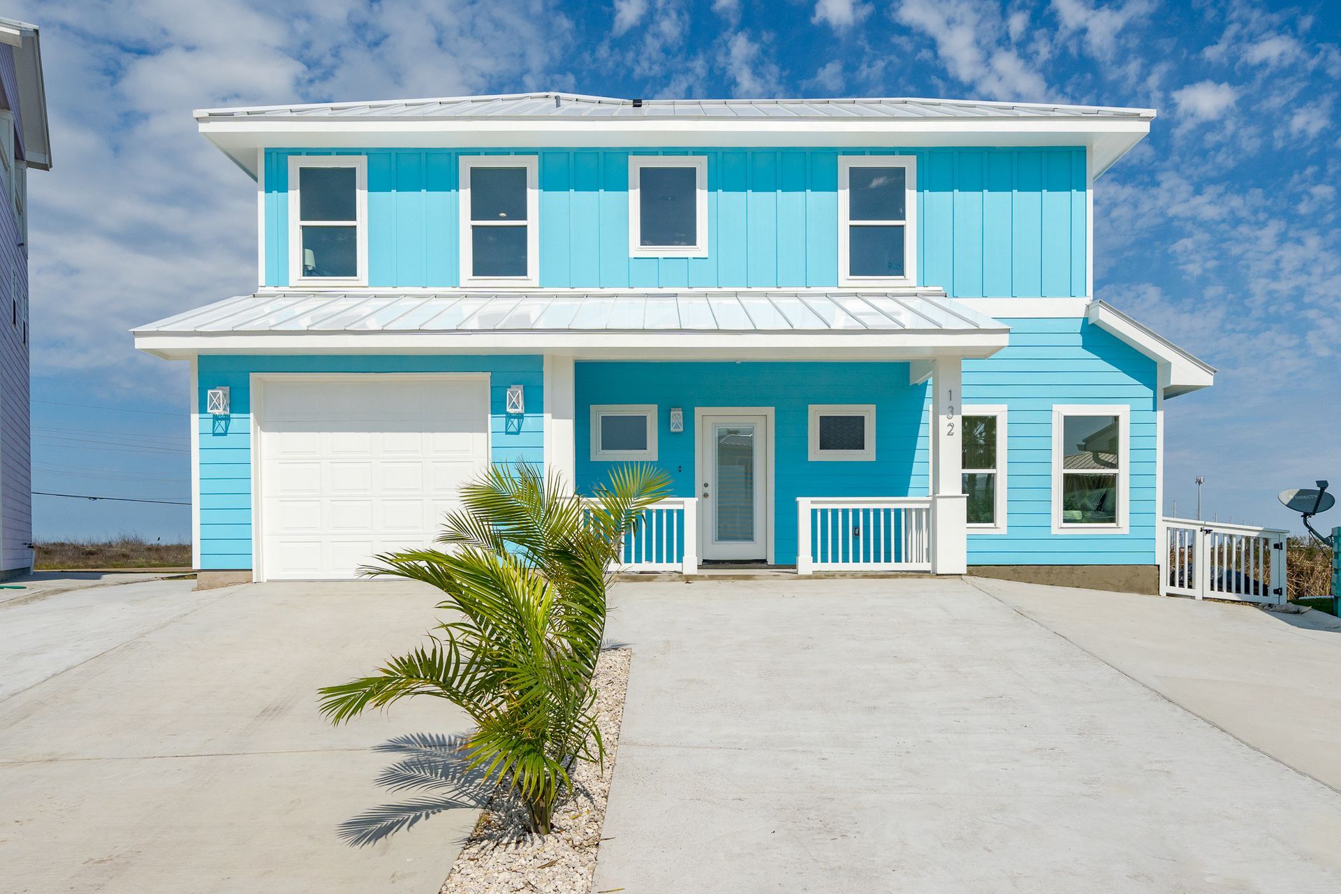 A blue and white house with a white garage door