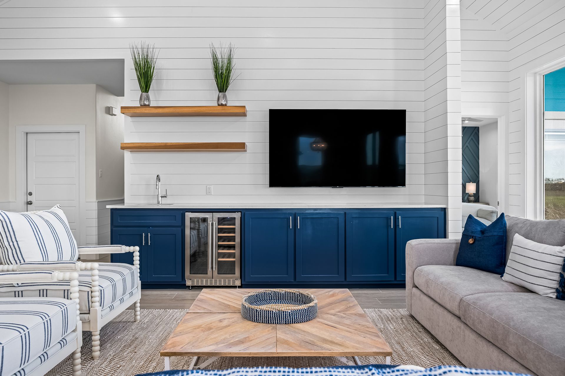 A living room with a couch , chairs , and a flat screen tv.