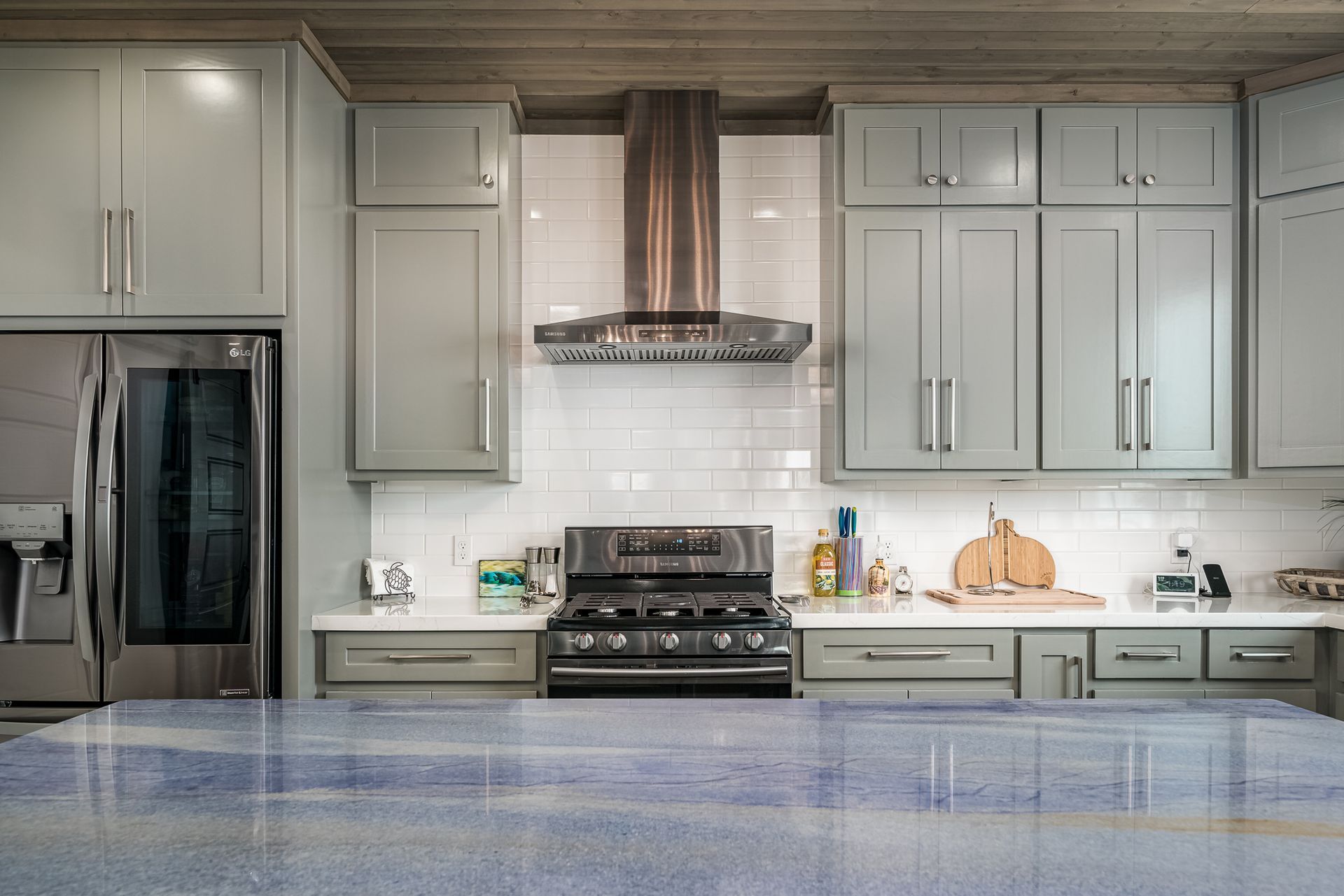 A kitchen with stainless steel appliances and gray cabinets