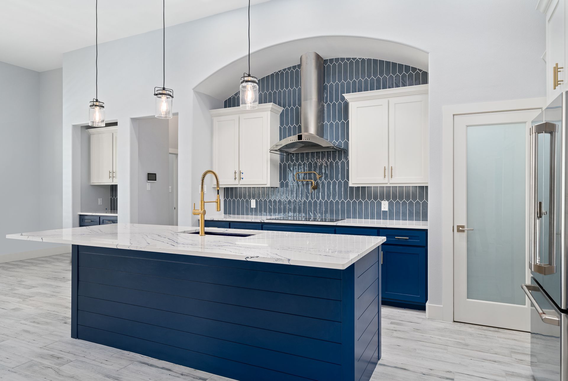 A kitchen with blue cabinets and white counter tops