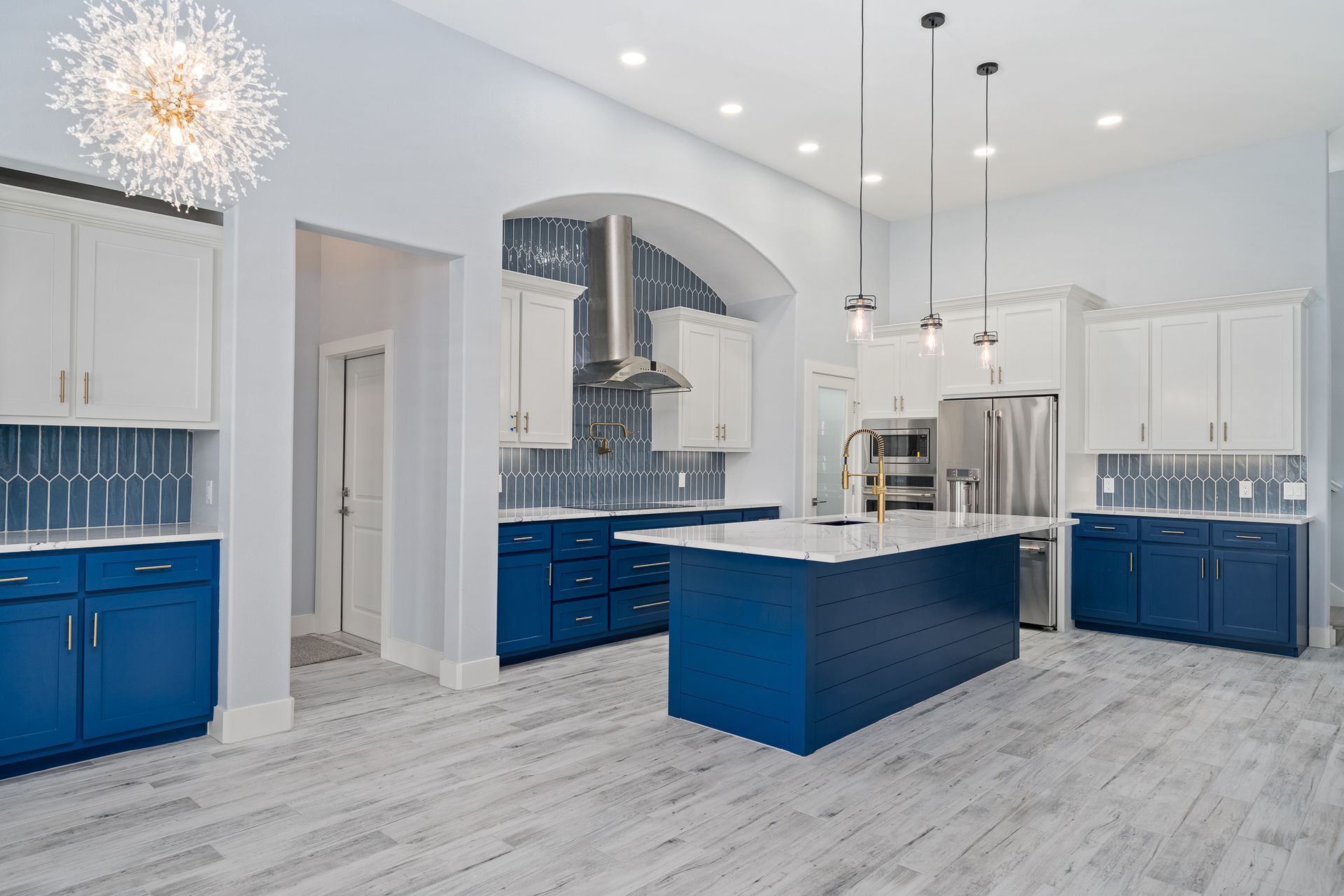 A kitchen with blue cabinets and white cabinets and a large island.