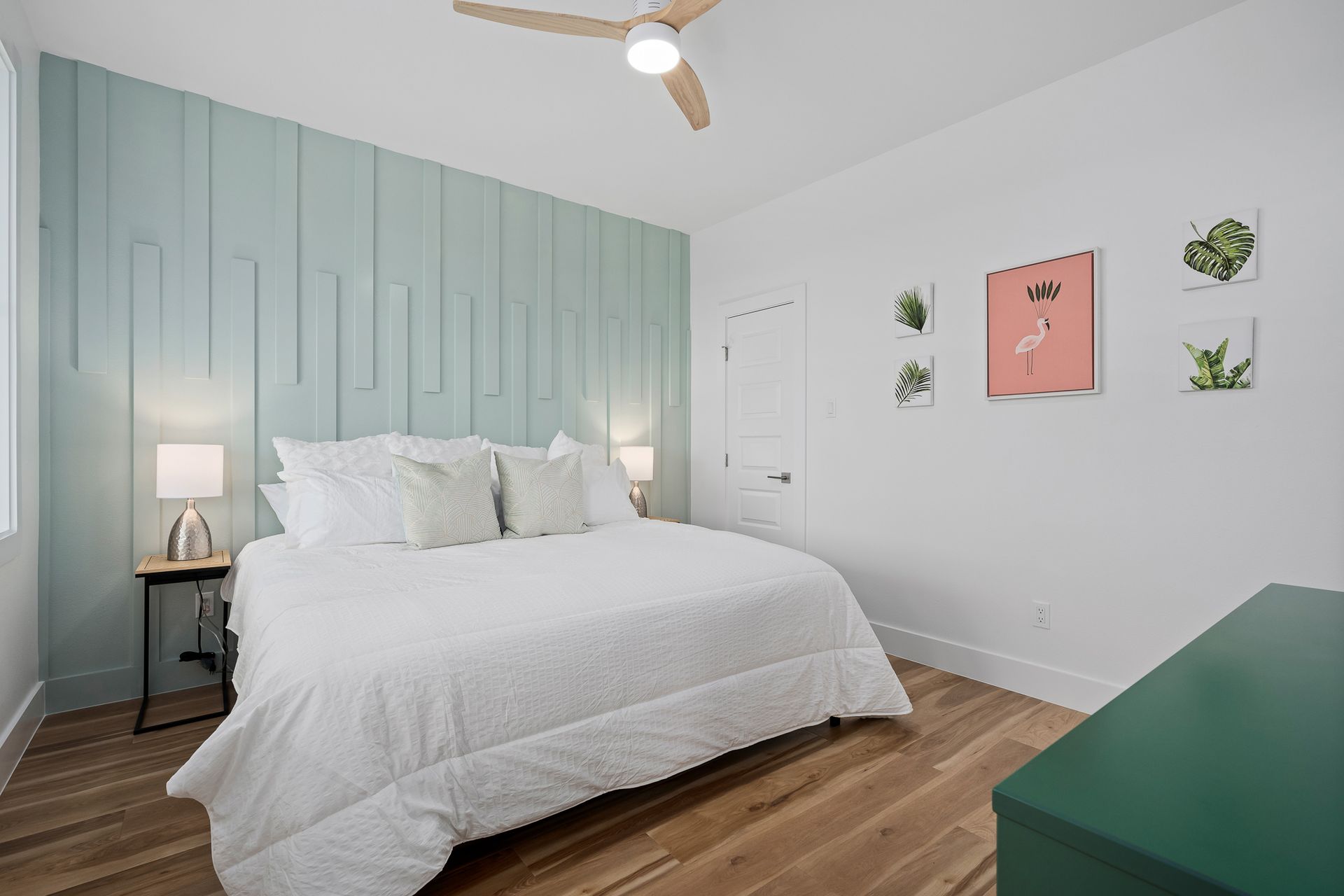 A bedroom with a king size bed and a ceiling fan.