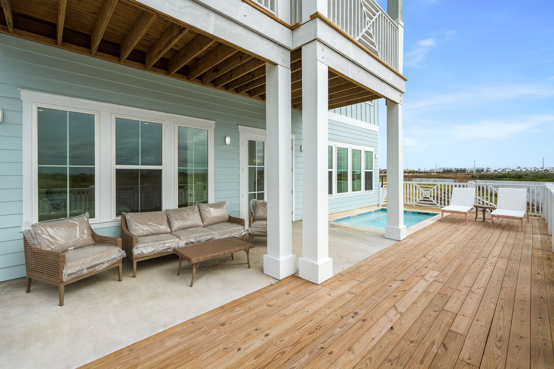 A large house with a wooden deck and a swimming pool.