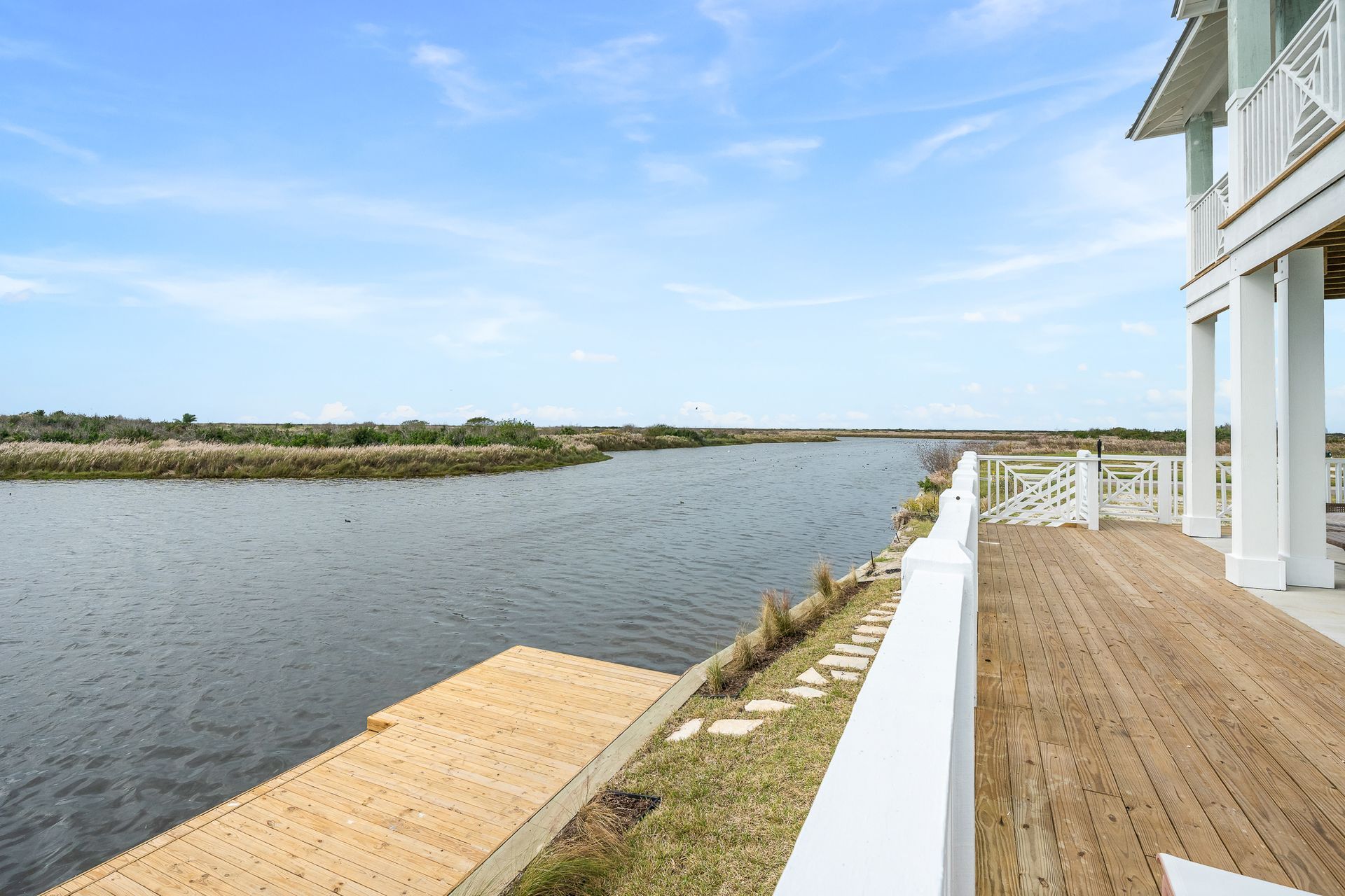 A house with a deck overlooking a large body of water.