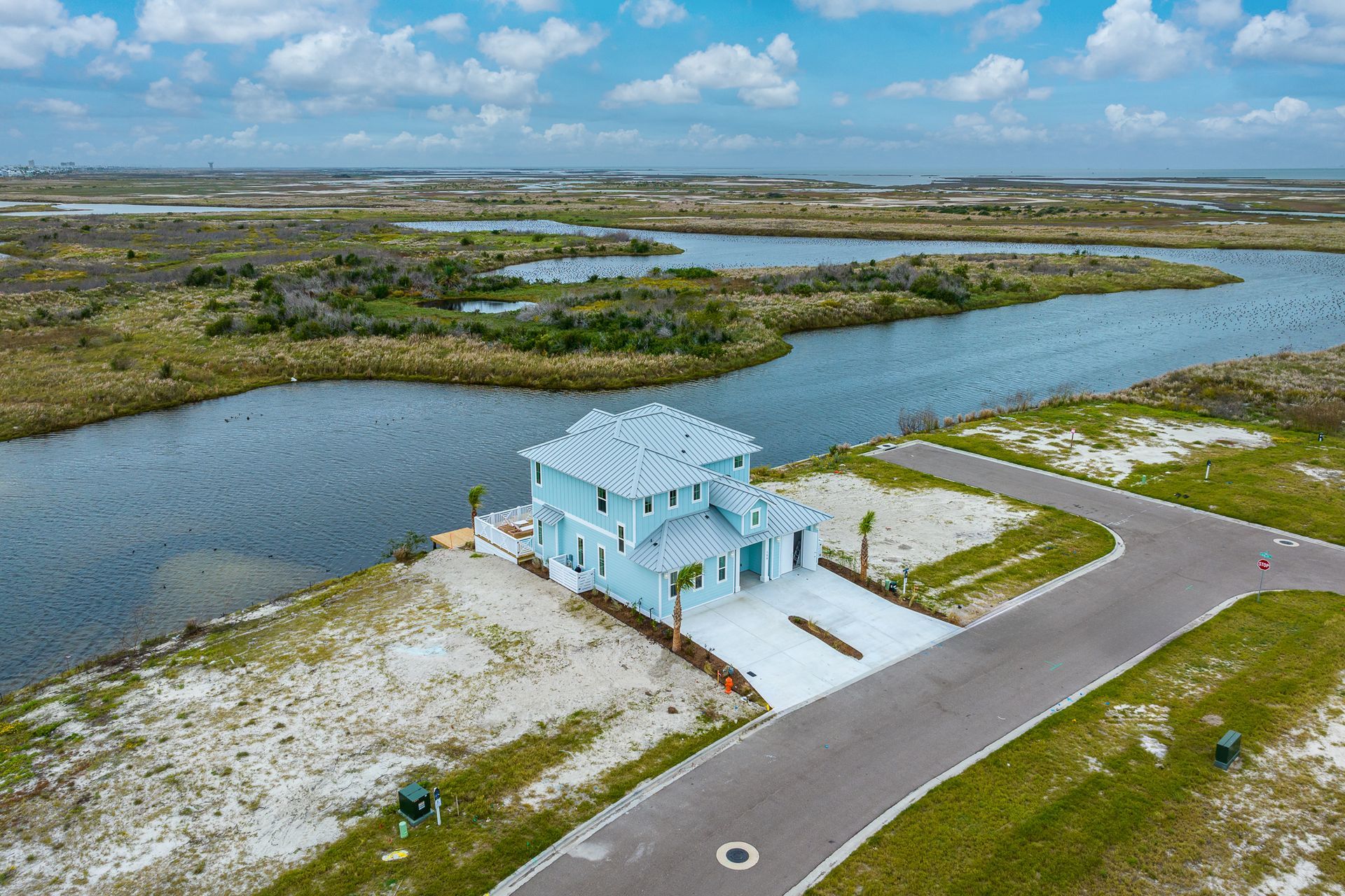 An aerial view of a house on a small island in the middle of a body of water.