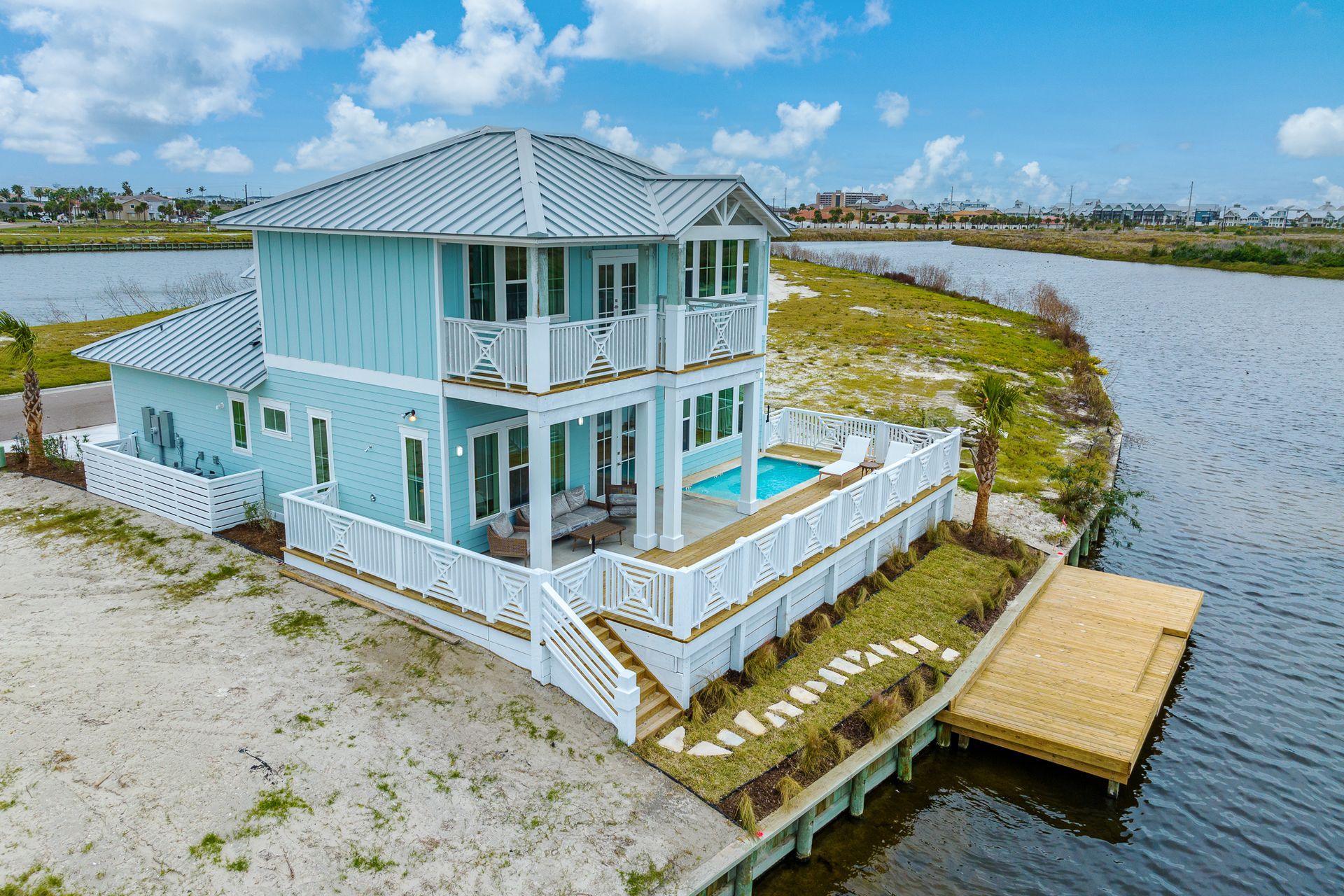 An aerial view of a house on a small island in the middle of a body of water.