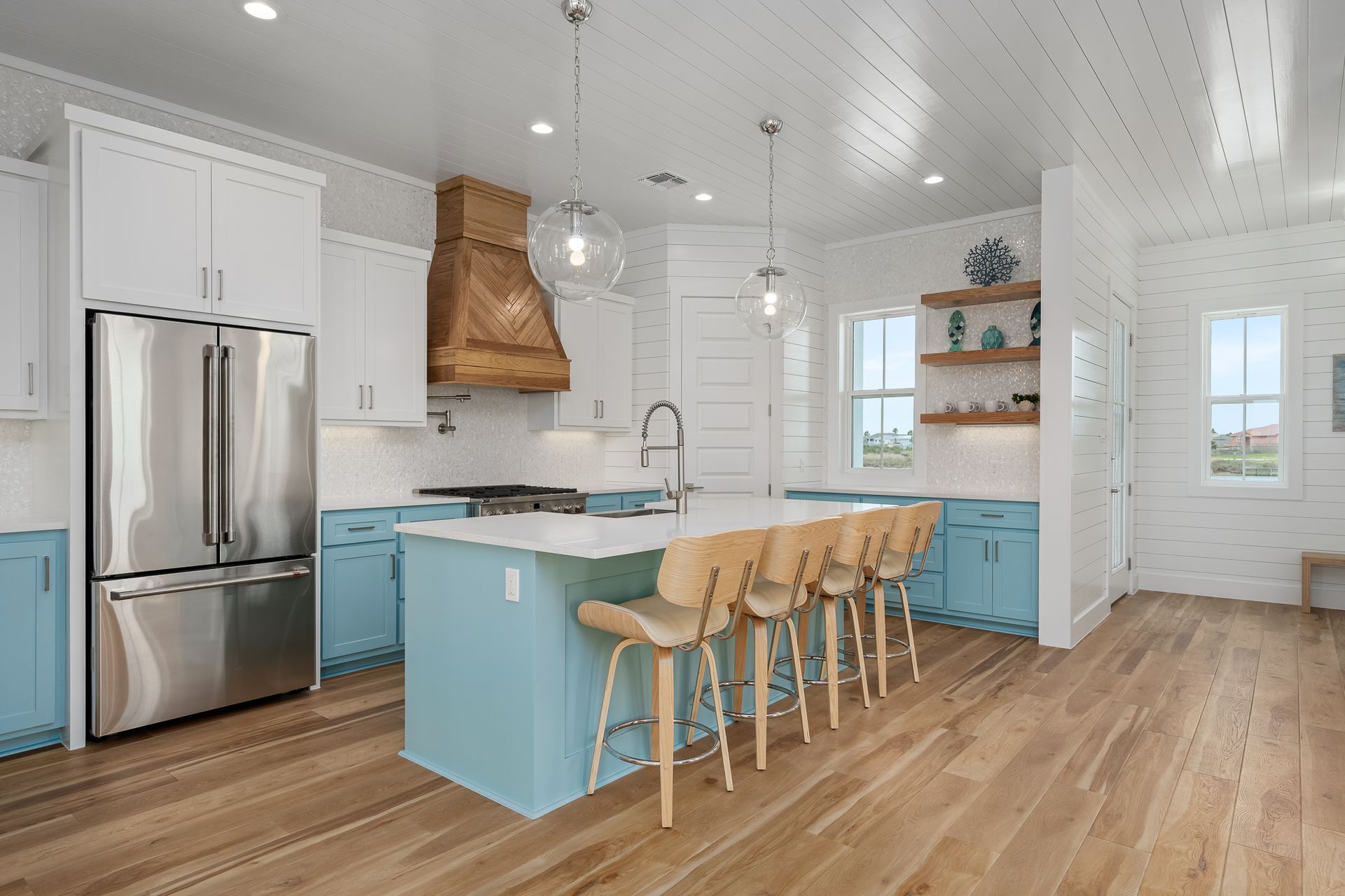 A kitchen with blue cabinets and stainless steel appliances