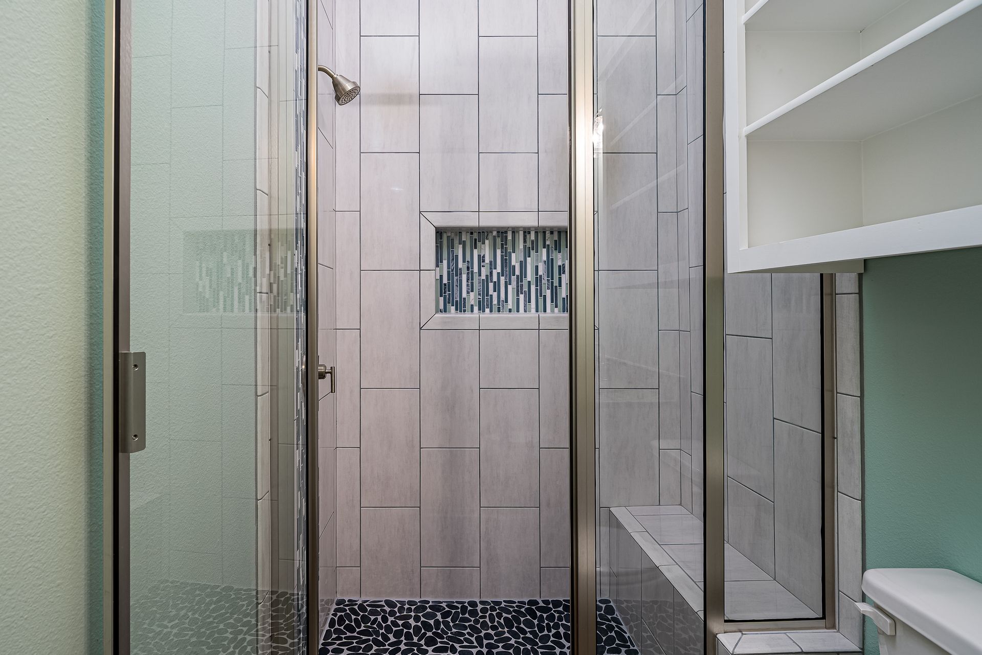 A bathroom with a walk in shower and a toilet