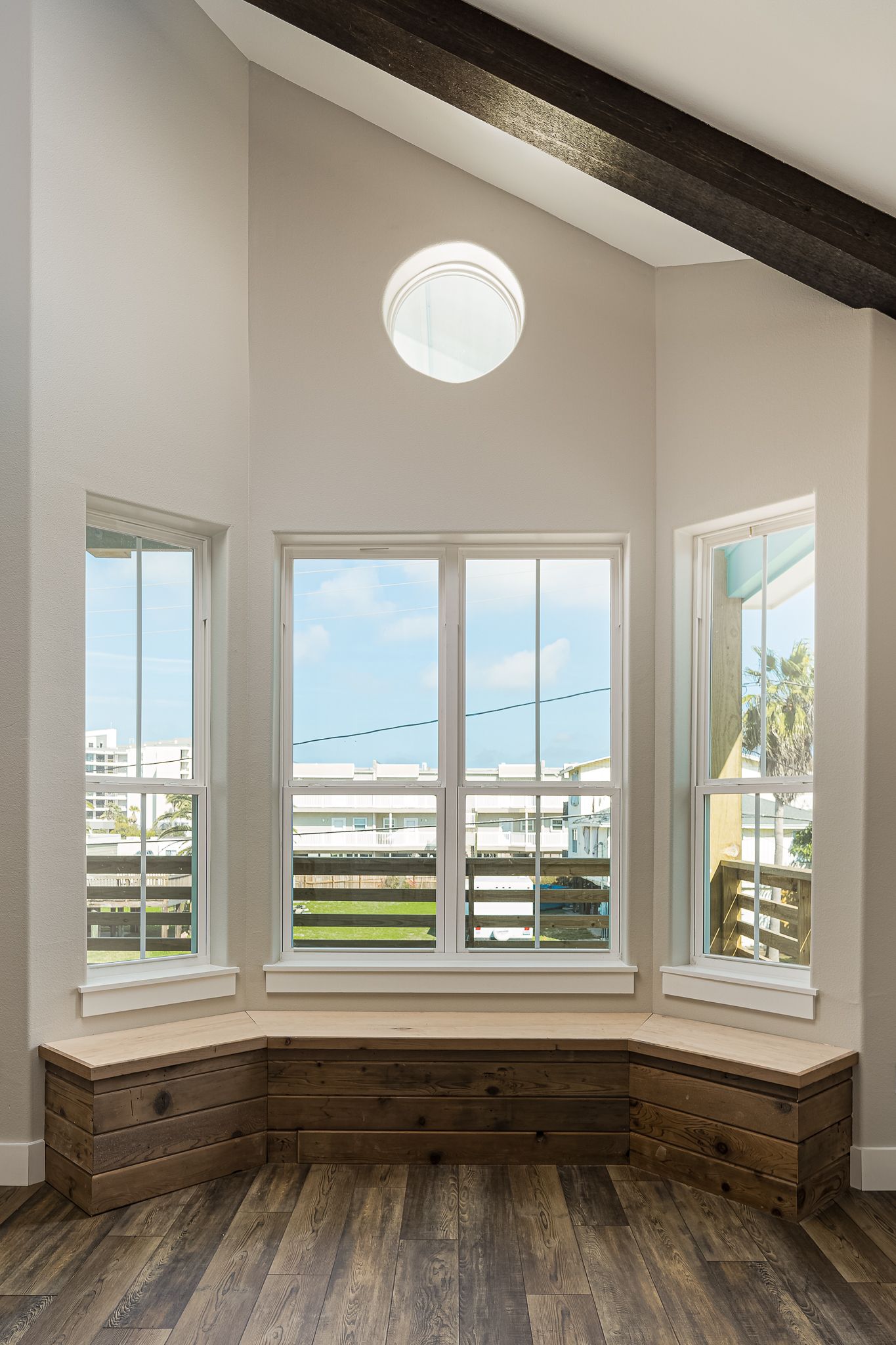 There is a window seat in the corner of the room with a view of the ocean.