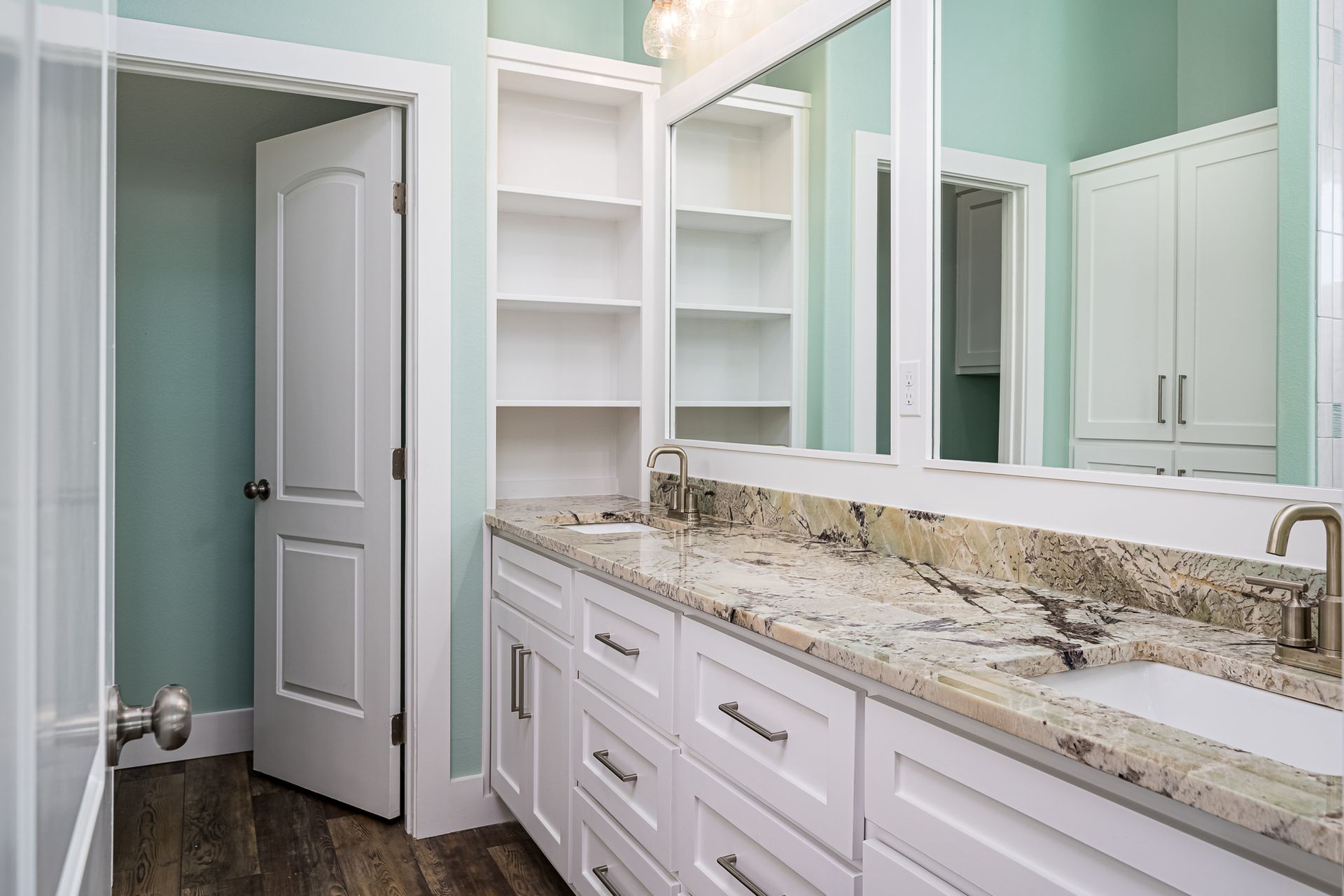 A bathroom with two sinks and a large mirror.