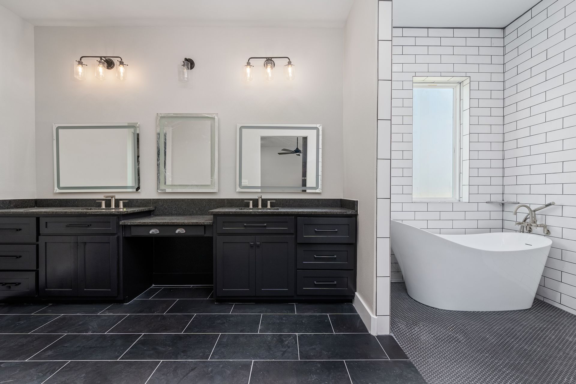 A bathroom with two sinks , two mirrors and a bathtub.