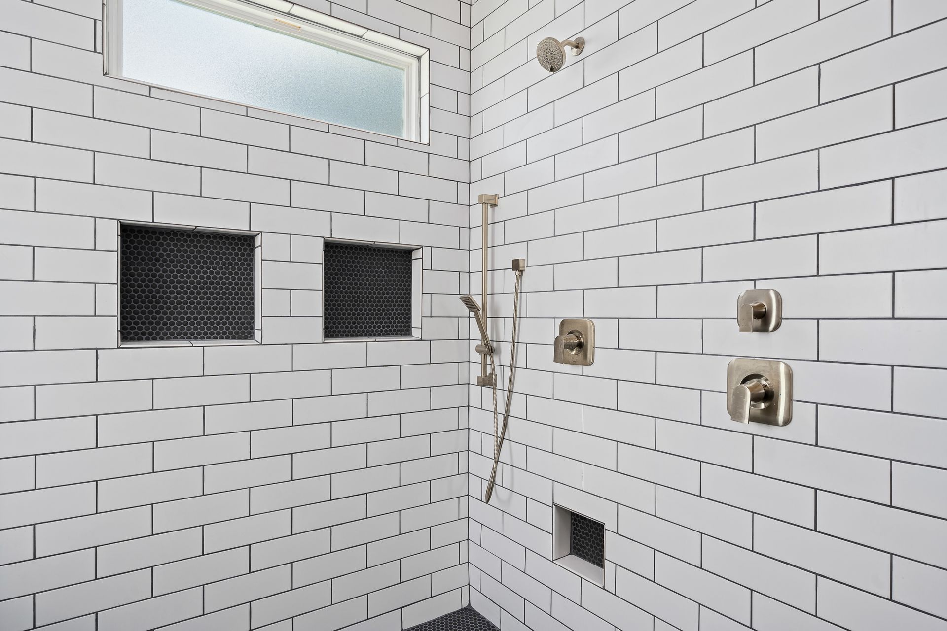 A shower with a brick wall and a window