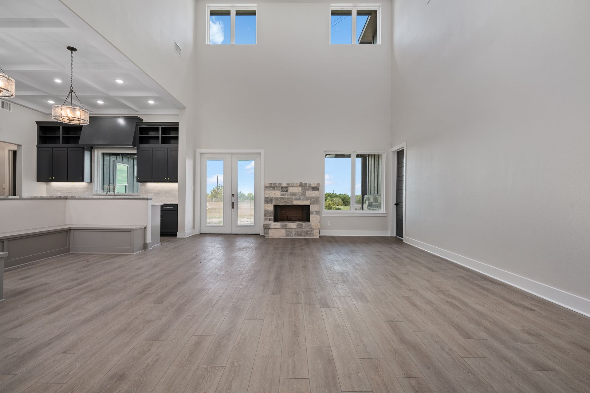 A large empty living room with hardwood floors and a fireplace.