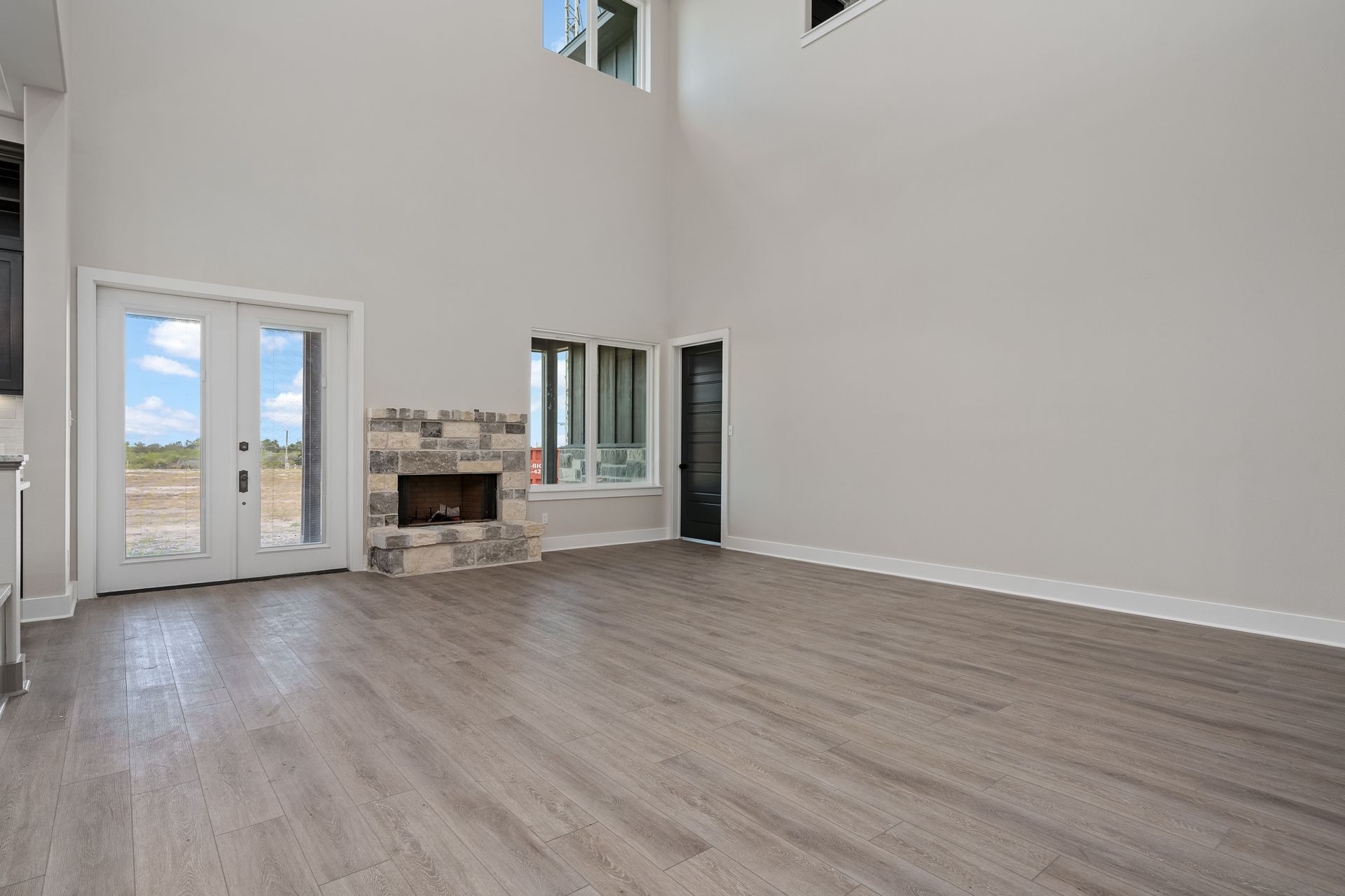 An empty living room with hardwood floors and a fireplace.